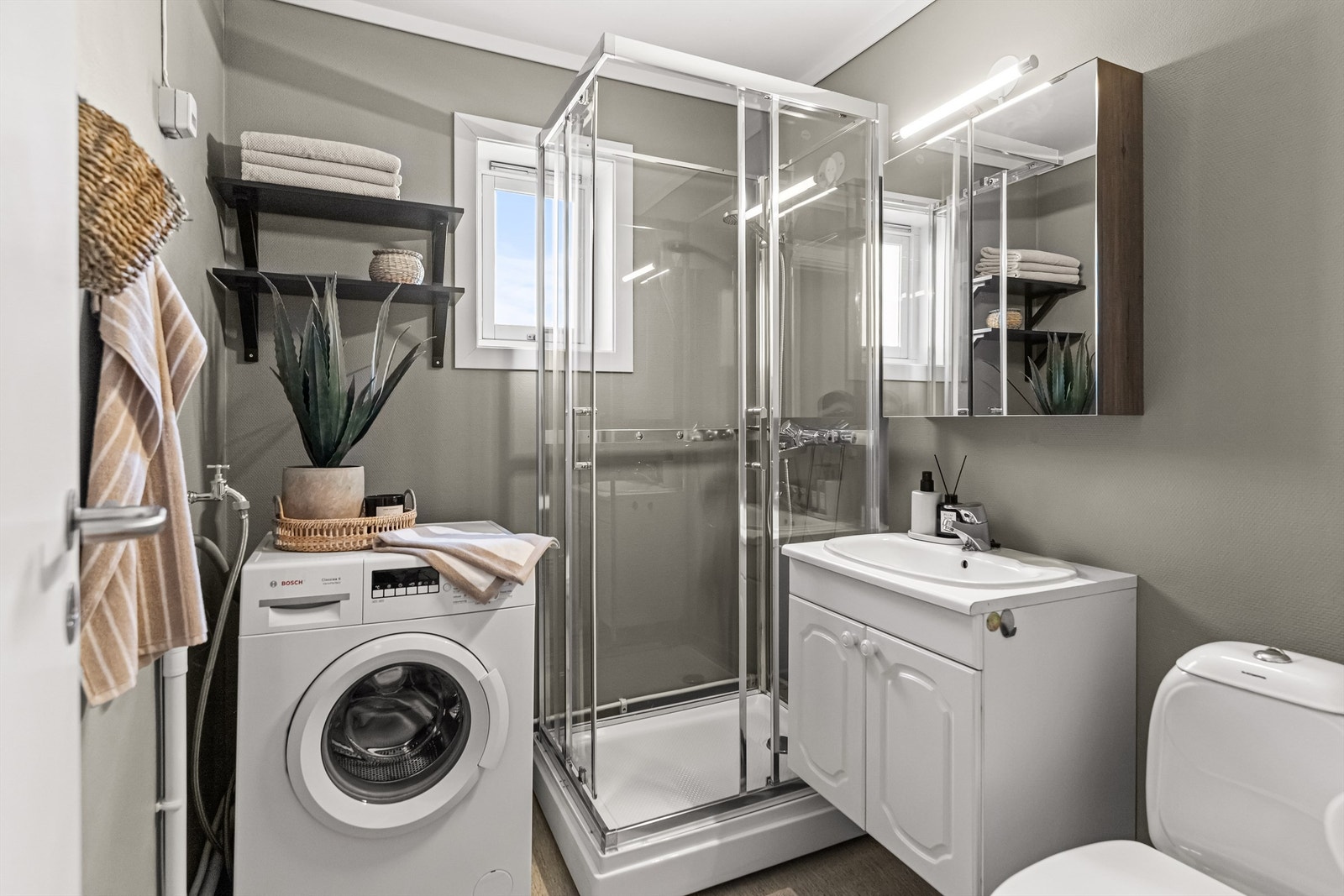 Baderommet er utstyrt med dusjkabinett, servant i innredning og er ferdig oppkoblet for vaskemaskin Galleribilde