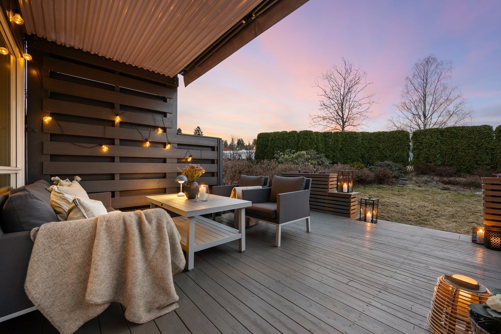 Terrassen er skjermet med levegger og hagen er omkranset av busker. Her kan barna leke fritt. Galleribilde