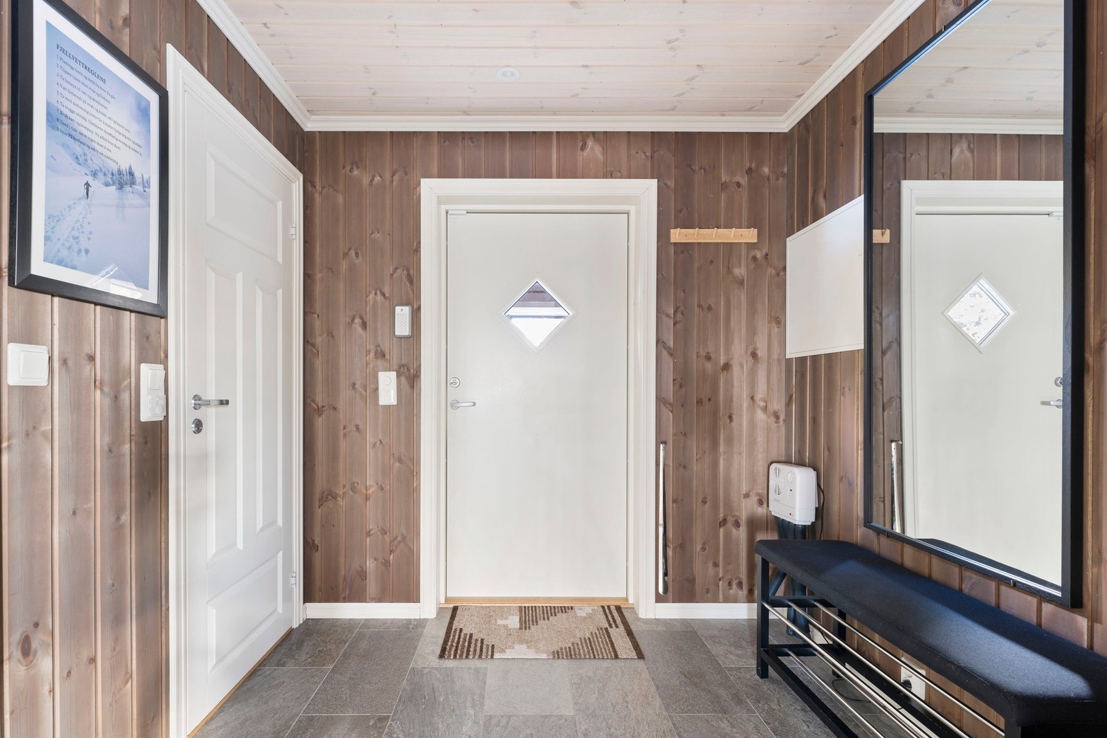 Velkommen inn i en lys og innbydende entré med flislagt gulv og gulvvarme. Galleribilde