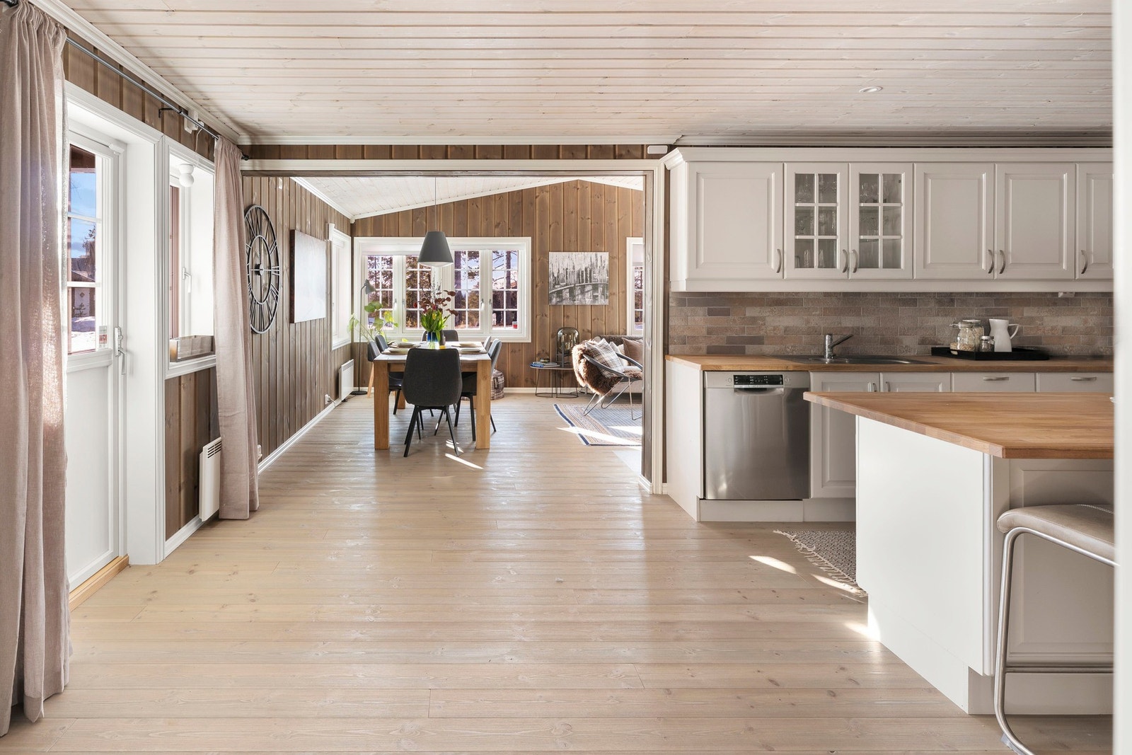 Stilrent kjøkken med profilerte hvite fronter og trebenkeplate. Galleribilde