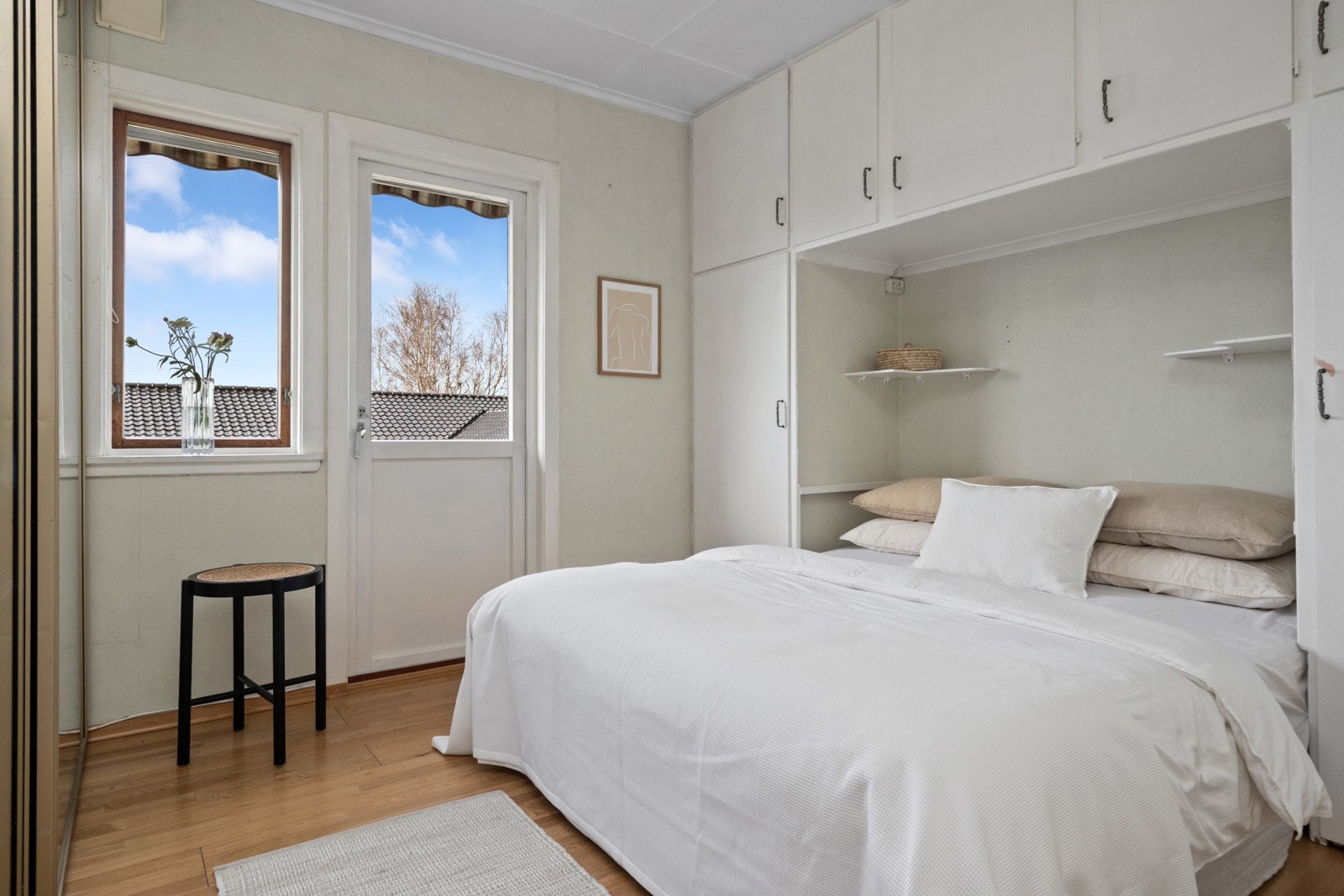 To soverom ligger vegg i vegg, med plassbygde skap montert over og ved siden av den avsatte plassen for seng. Galleribilde