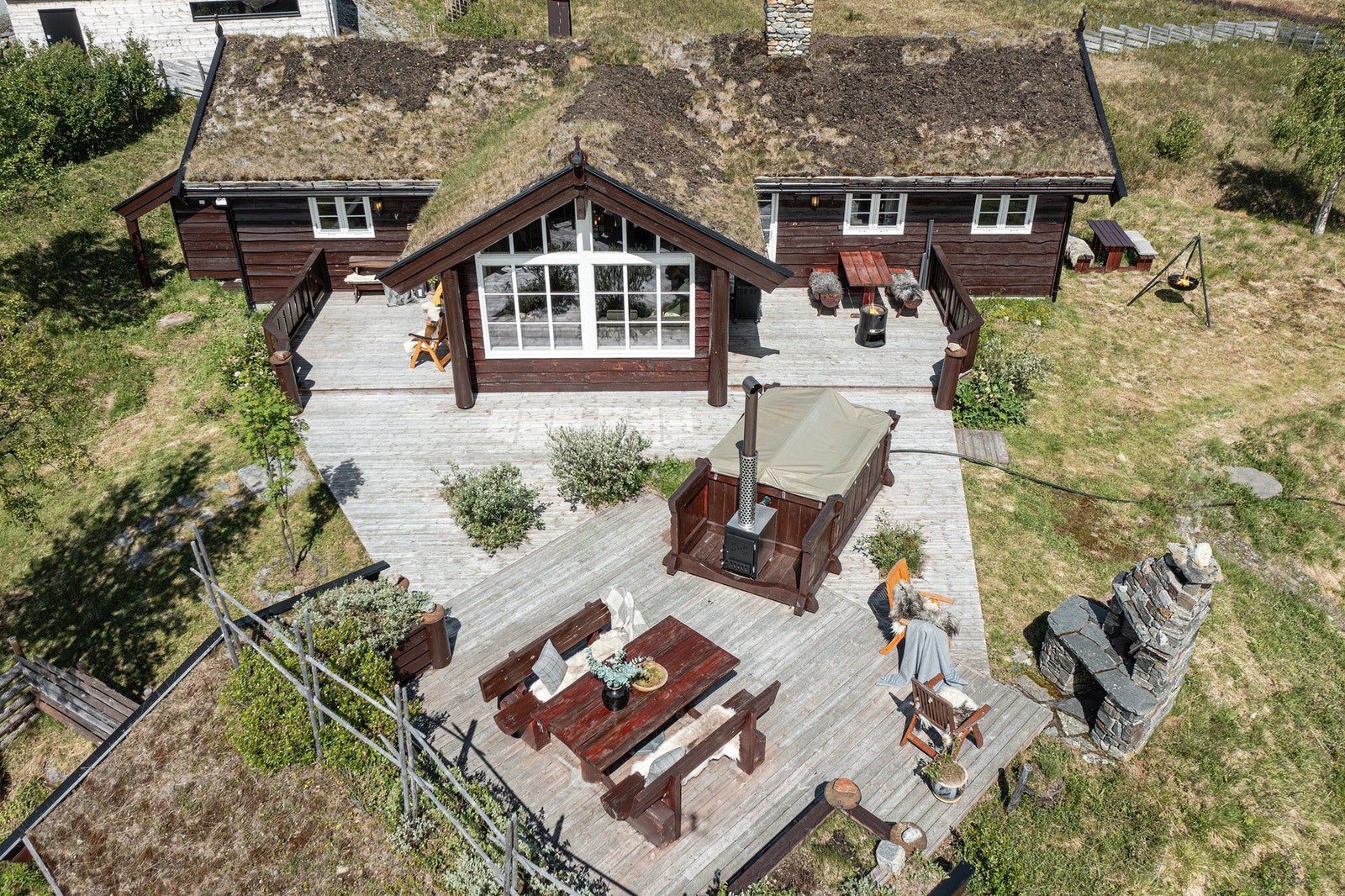 Terrasse på over 100 kvm med flere sittesoner, bygd slik at du kan følge sola rundt hytta i flere lune kroker. Galleribilde