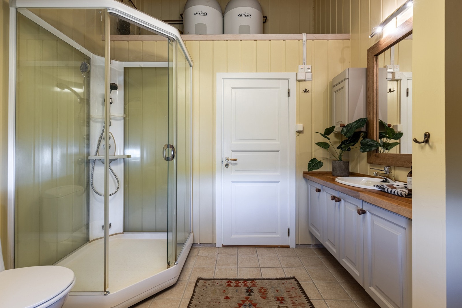 Hovedbadet har dusj, toalett, innredning med eik benkeplate og opplegg for vaskemaskin. Galleribilde