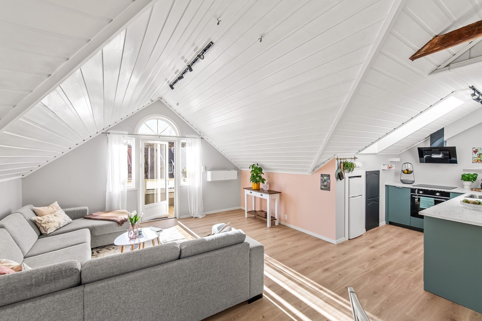 Stuen er lys og koselig stue med sjarmerende takvinkler som gir leiligheten særpreg. Galleribilde