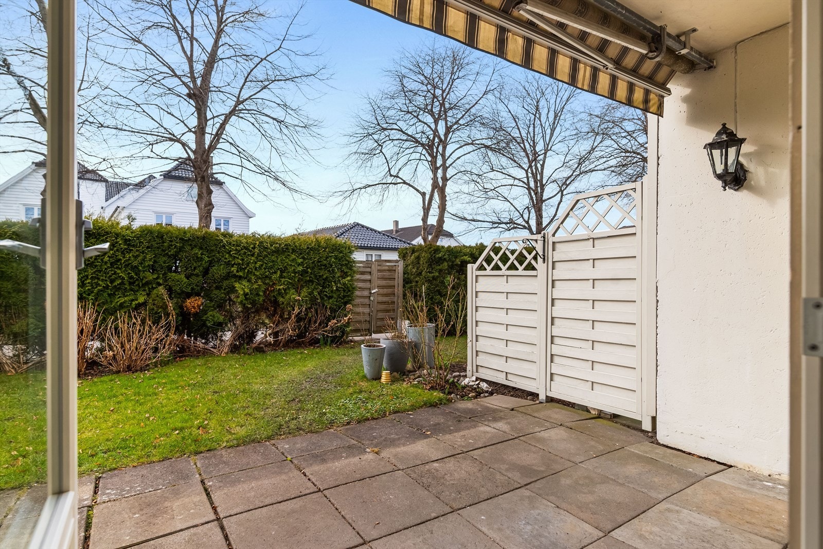 Det er dekke av betongheller, levegg mot nabo i nord og hekk mot vest. Det er direkte adgang til gressplen i vest. Galleribilde