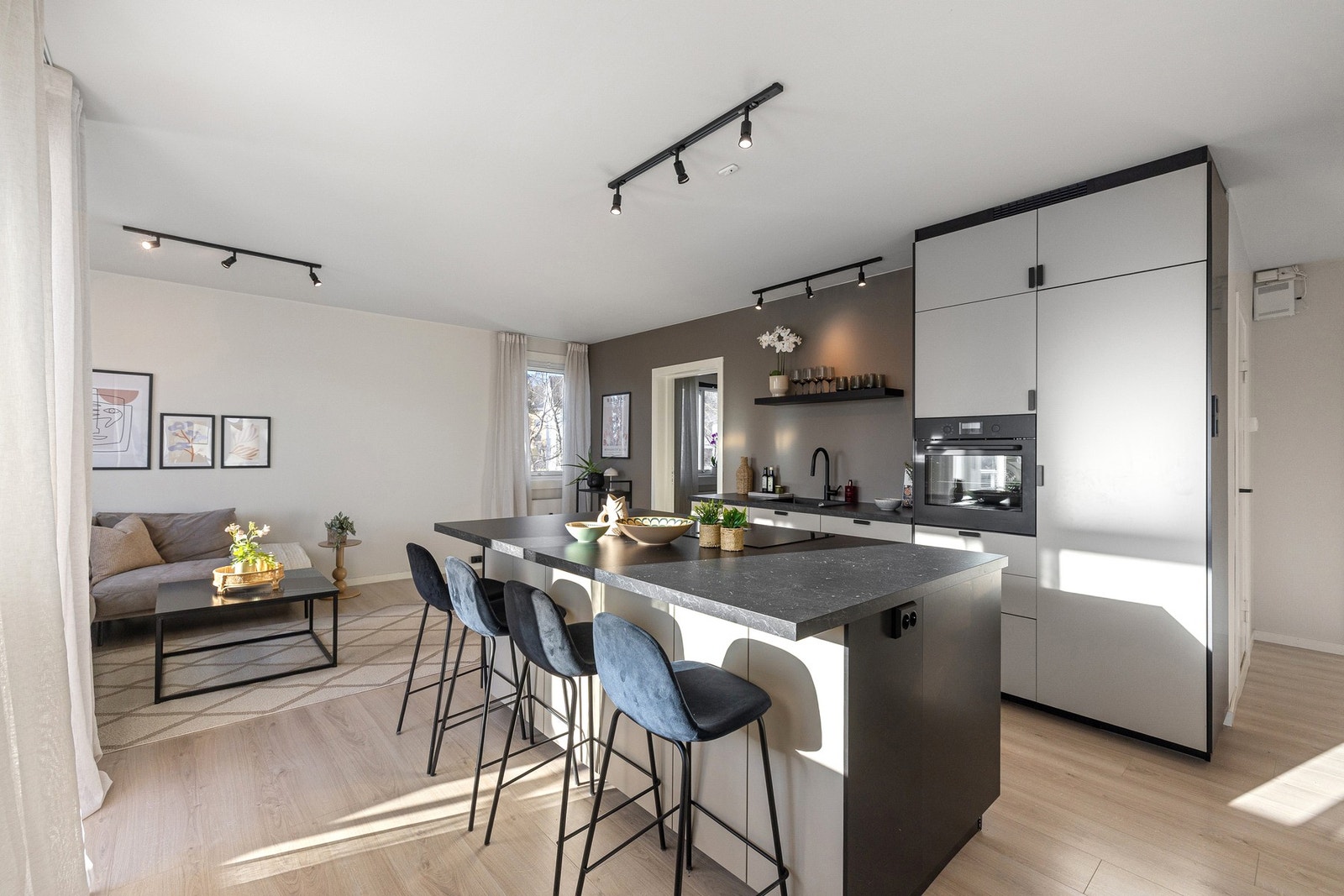 Moderne og stilrent IKEA-kjøkken fra 2024 med åpen løsning mot stuen, som skaper en sosial og funksjonell arena for både matlaging og samvær. Galleribilde