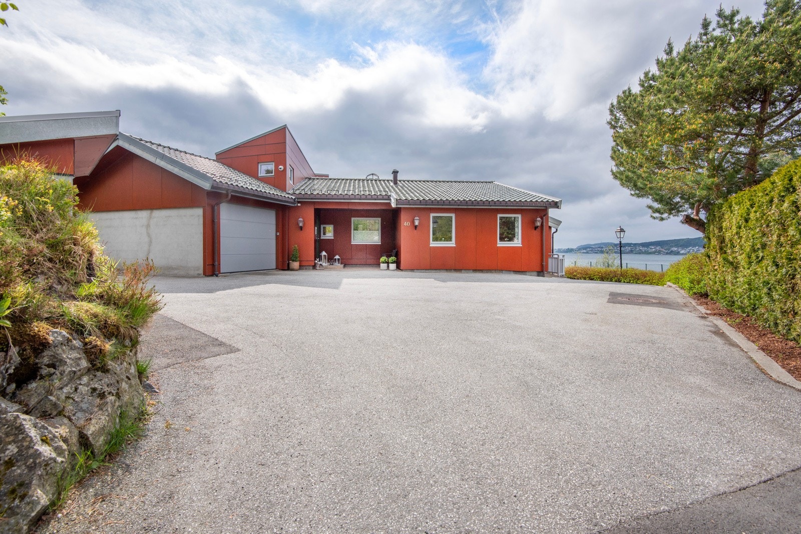 Asfaltert innkjørsel. Parkering kan gjøres i garasje eller på gårdsplass. Galleribilde