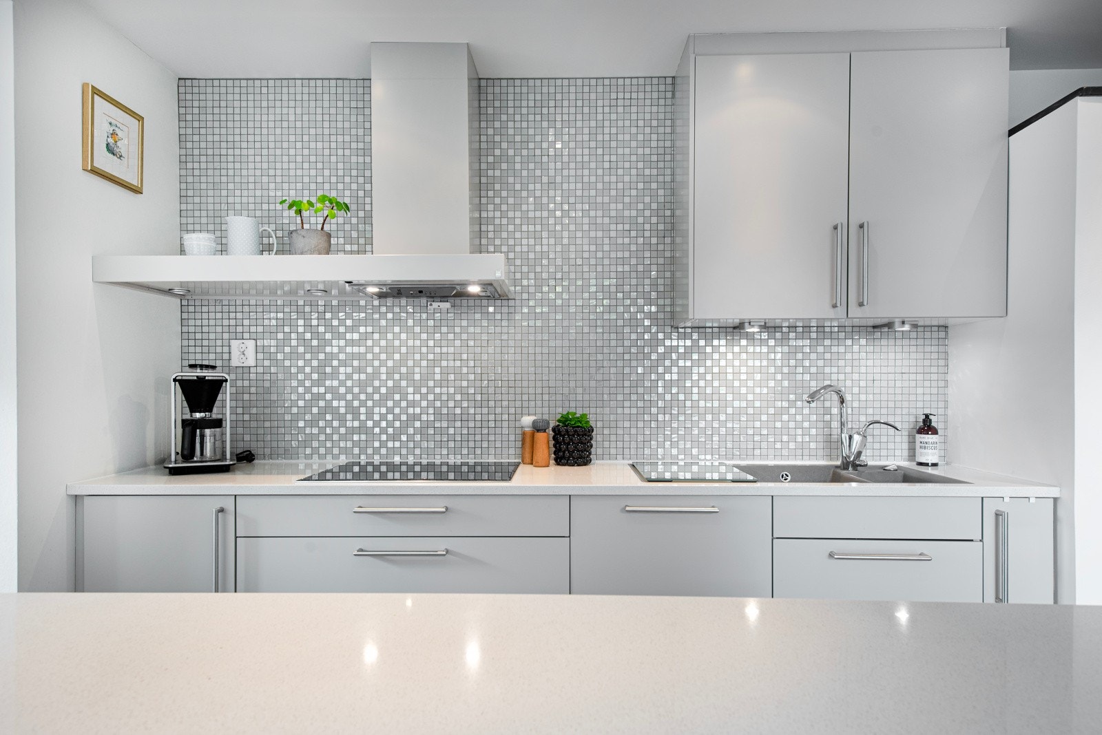 Kjøkkeninnredningen har glatte skap- og skuffefronter i en delikat farge. Det er integrerte hvitevarer. Galleribilde