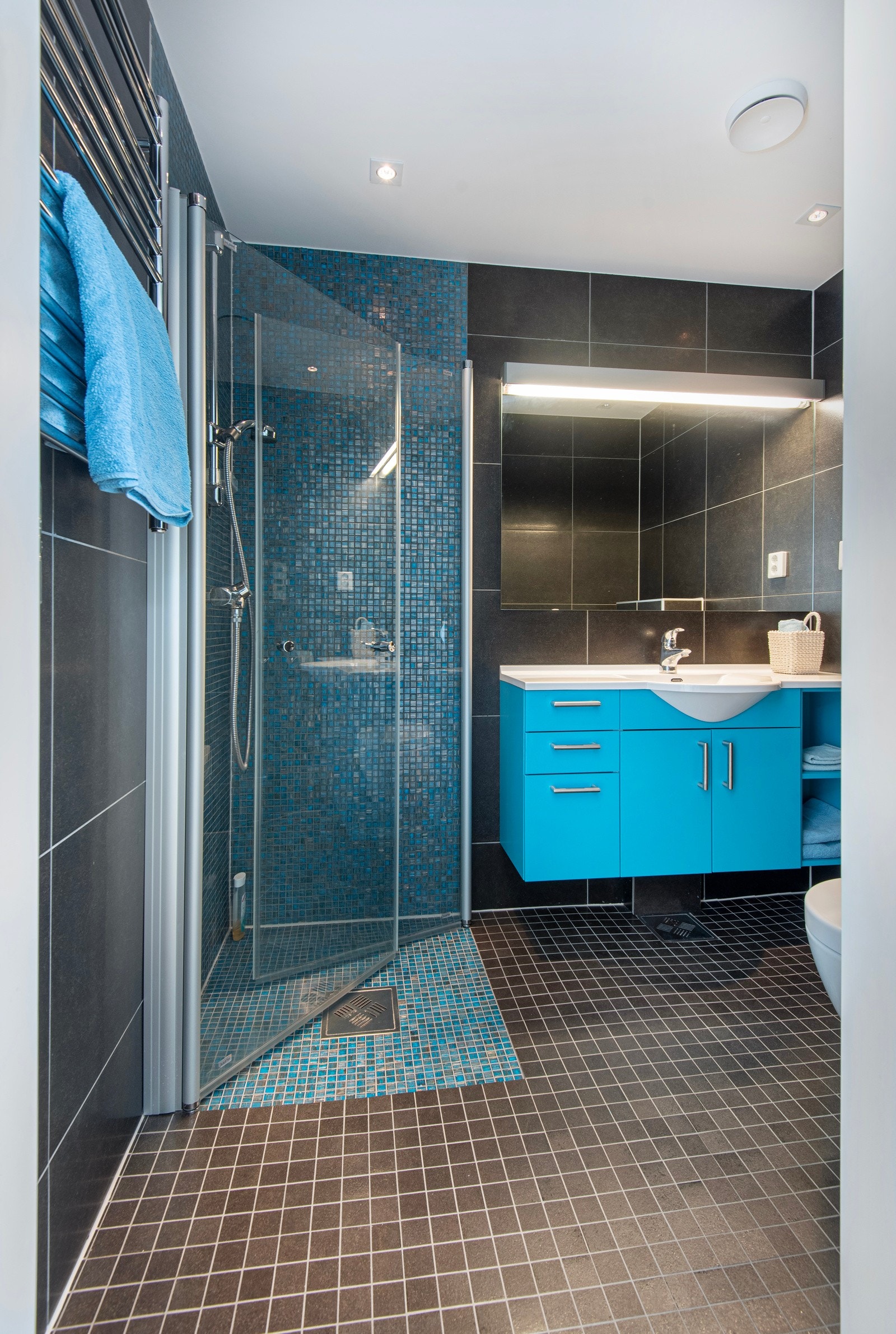 Badet i øverste etasje er pent flislagt og har spreke fargedetaljer i innredningen. Her er det dusj og wc. Galleribilde