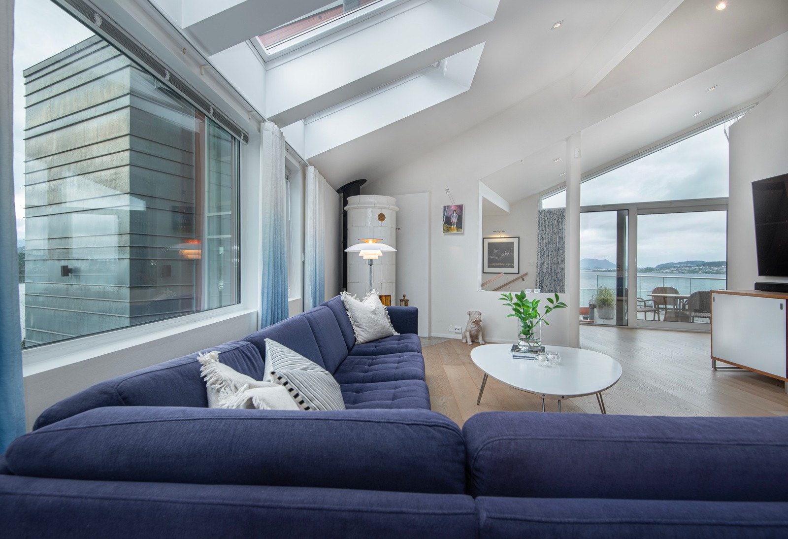 Et lyst og hyggelig rom med kakkelovn og god atmosfære. Skyvedører til terrasse og nydelig utsikt. Galleribilde