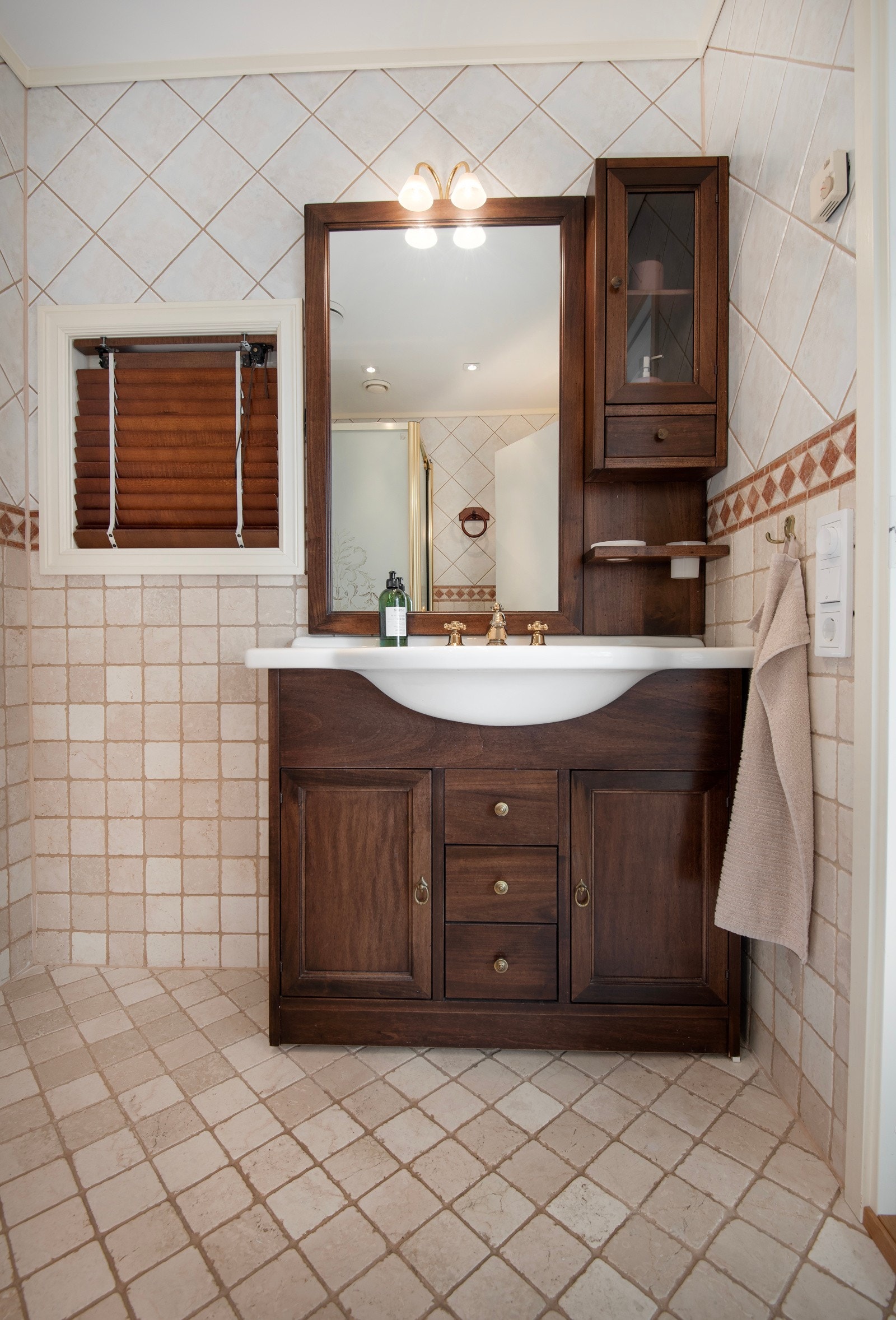 Bad nr 2 har baderomsinnredning med mørke trefronter og speil med belysning over servant. Galleribilde