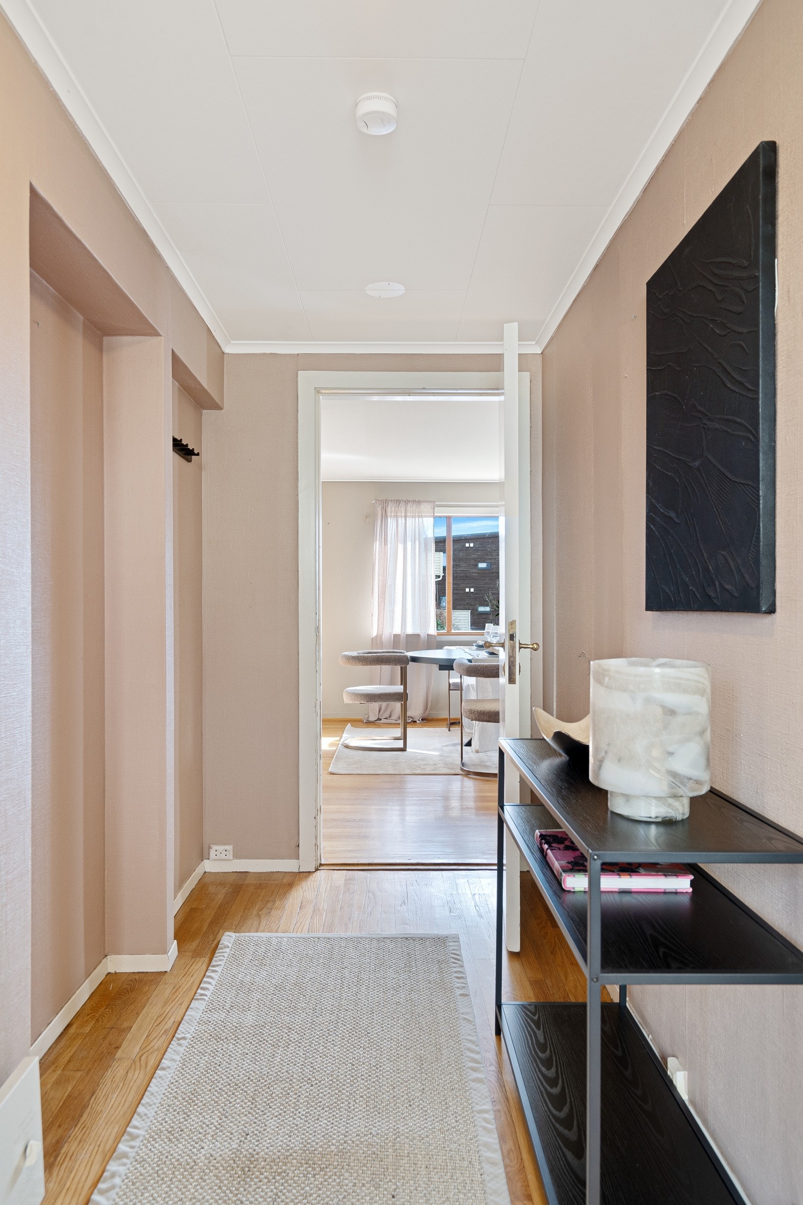 Lys og delikat gang fra entre, leder til WC-rom, kjøkken og stue. Galleribilde