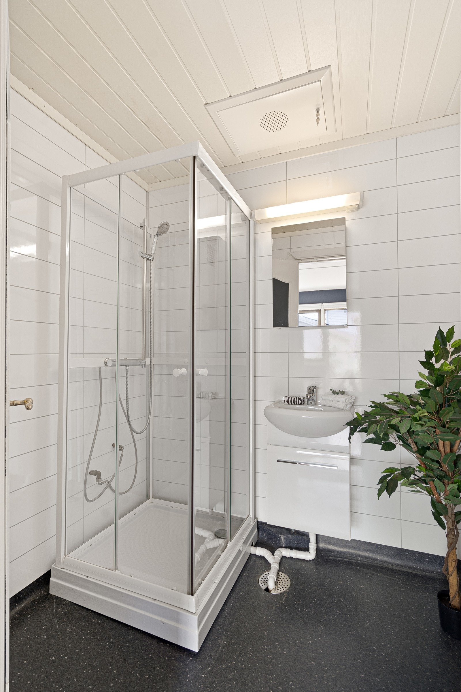 Badet ble pusset opp i 2005, innredet med mørkt gulvbelegg og hvite, flismønstrede våtromsplater på veggene. Galleribilde