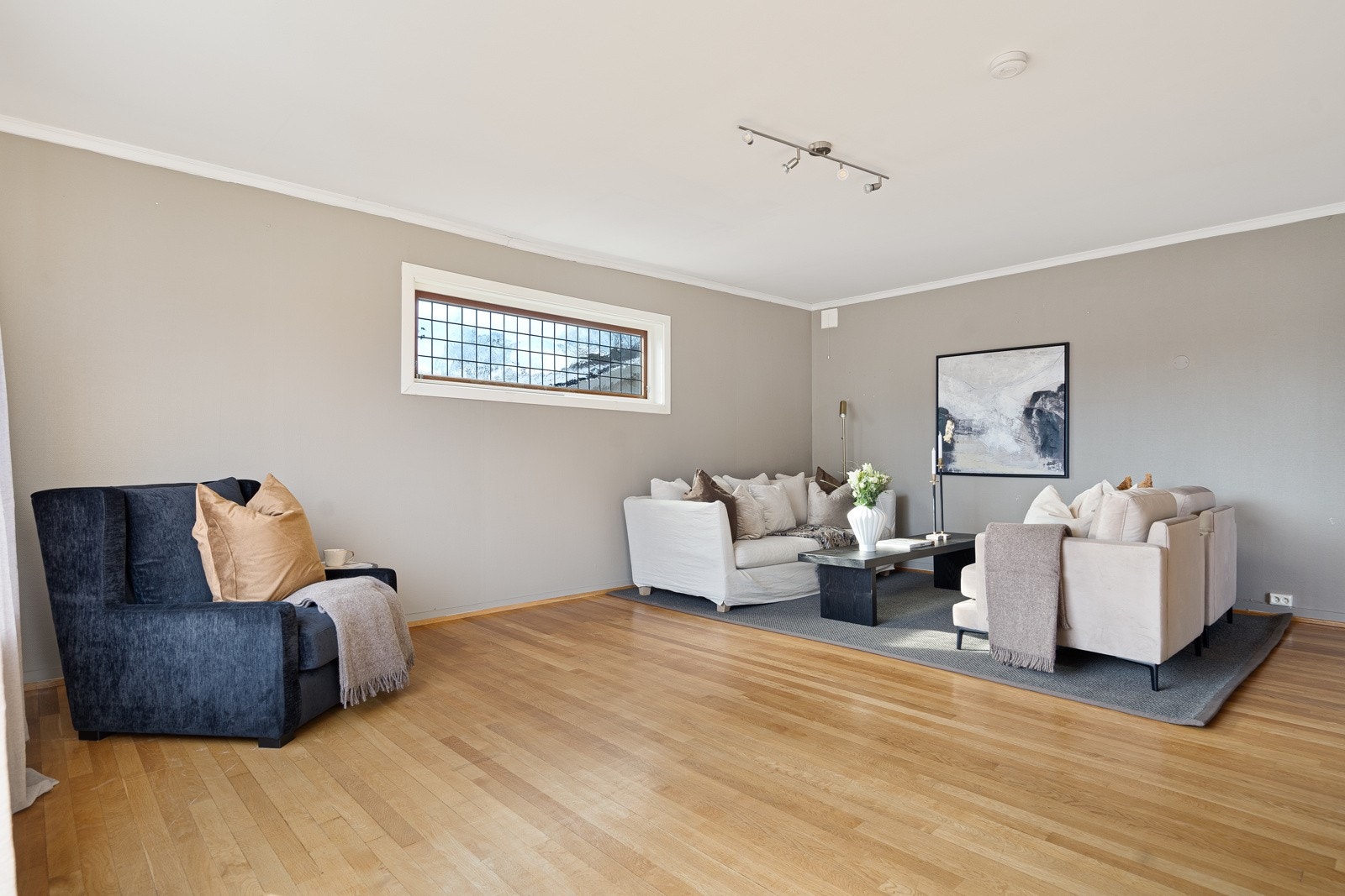 Parkettgulv og gråmalte vegger bidrar til en flytende overgang mellom rommene. Galleribilde