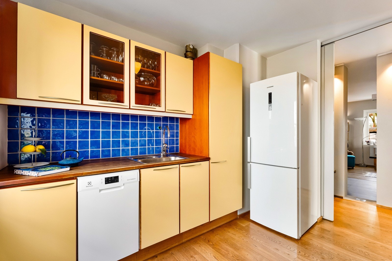 Opplegg for vaskemaskin og velegnet plass til frittstående kjøleskap og komfyr under kjøkkenventilator i innredningen. Galleribilde