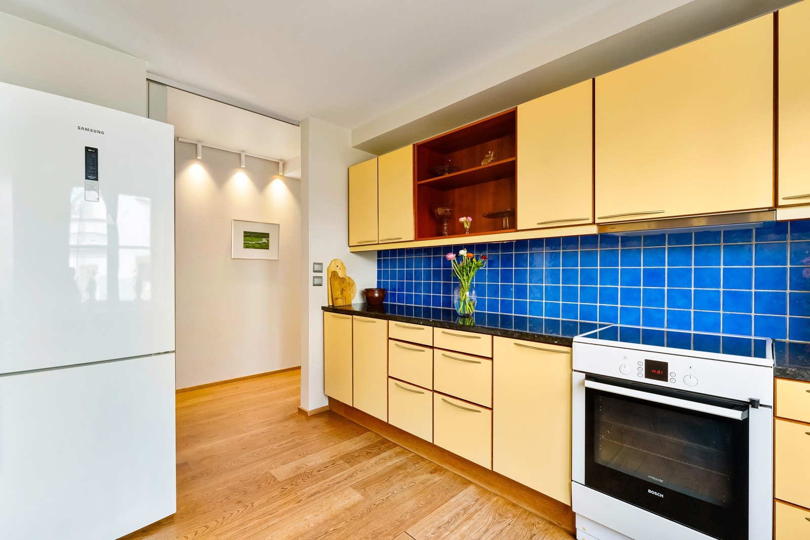 Kjøkkeninndrening med glatte fronter. Benkeplate av delevis stein og heltre. Galleribilde