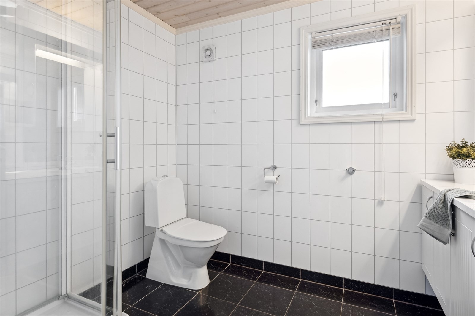 Badet er utstyrt med dusjkabinett, toalett og servant med under- og overskap. Galleribilde