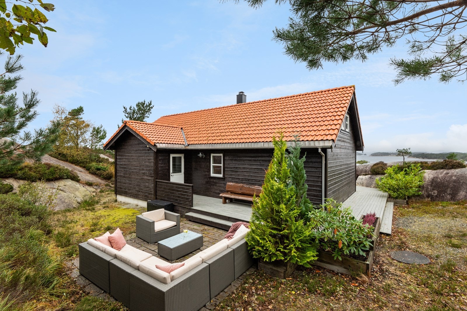 Inngangspartiet på hytta er ein del av terrassen og går rundt på framsida av hytta. Galleribilde
