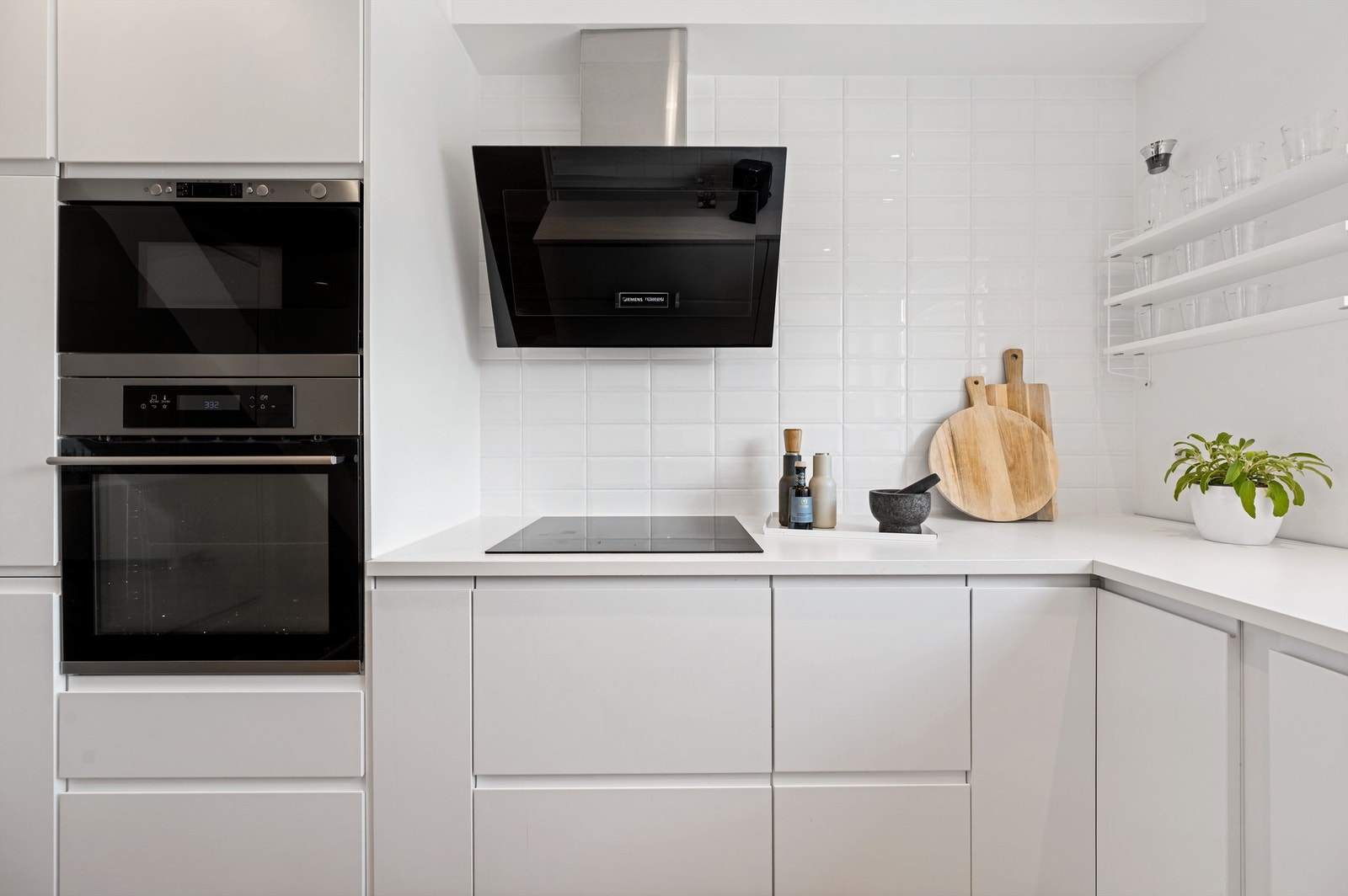 Fliser på vegg mellom overskap og benk, i tillegg til stort vindu på endevegg som gir godt lysinnslipp og utsikt mot inngangsparti. Integrerte hvitevarer på kjøkken medfølger handelen. Galleribilde