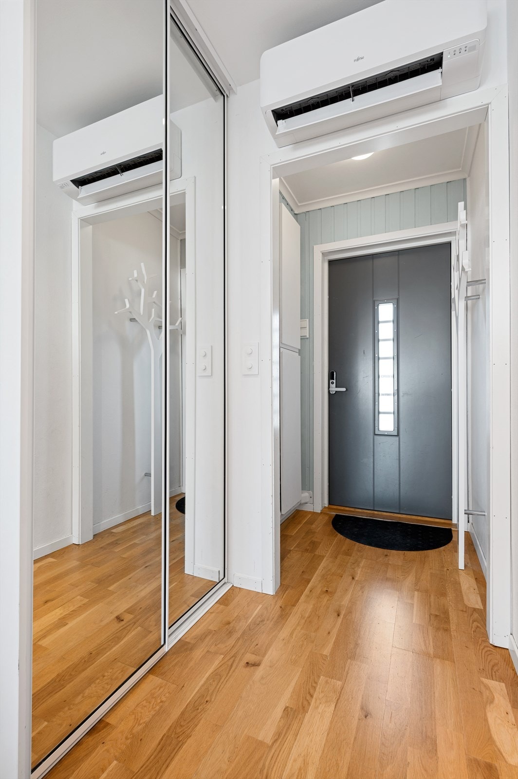 Entré med fliser på gulv, malte vegger i en fin tidsriktig farge og god plass til å henge av yttertøy. Galleribilde