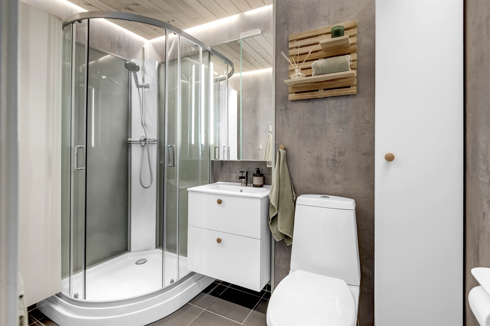 Bad med baderomspanel på vegger og panel i himling. Servantinnredning med 1-greps blandebatteri. Speilskap over servant. Avløpsrør av plast og vannrør i kobber.
Dusjkabinett. Avtrekk på vegg tilkoblet felles anlegg. Gulvmontert toalett. Galleribilde