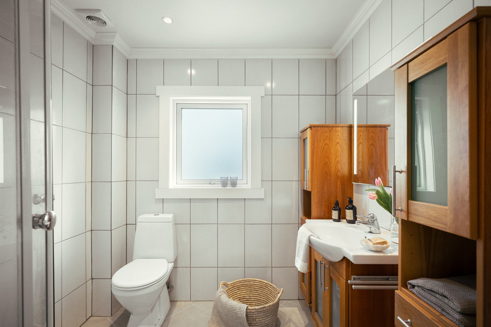 Badet, som ble pusset opp i 2019, er delikat med hvite veggfliser og store, lysegrå gulvfliser. Galleribilde