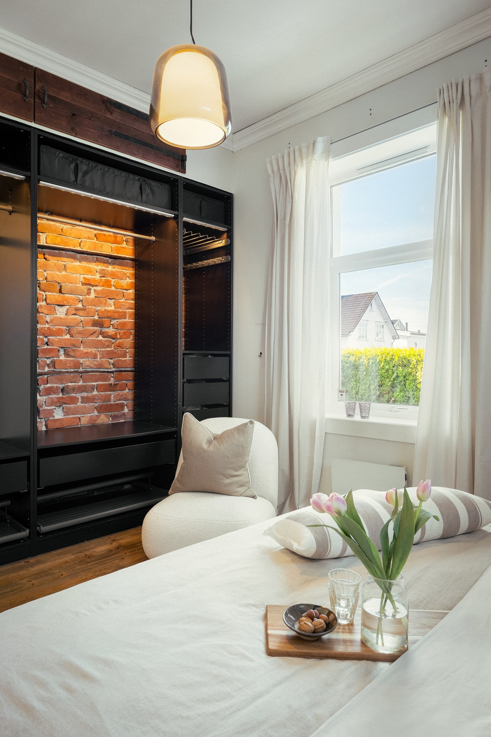 Langs den ene veggen har rommet et åpent skap med skuffer, hyller og stenger for oppheng. Galleribilde