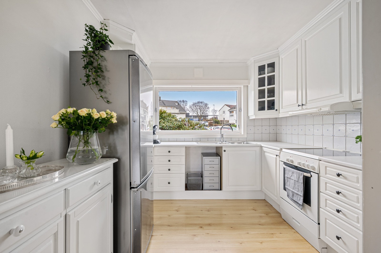 Det lyse kjøkkenet har innredning fra Møre Kjøkken og bader i naturlig lys fra stort vindu Galleribilde