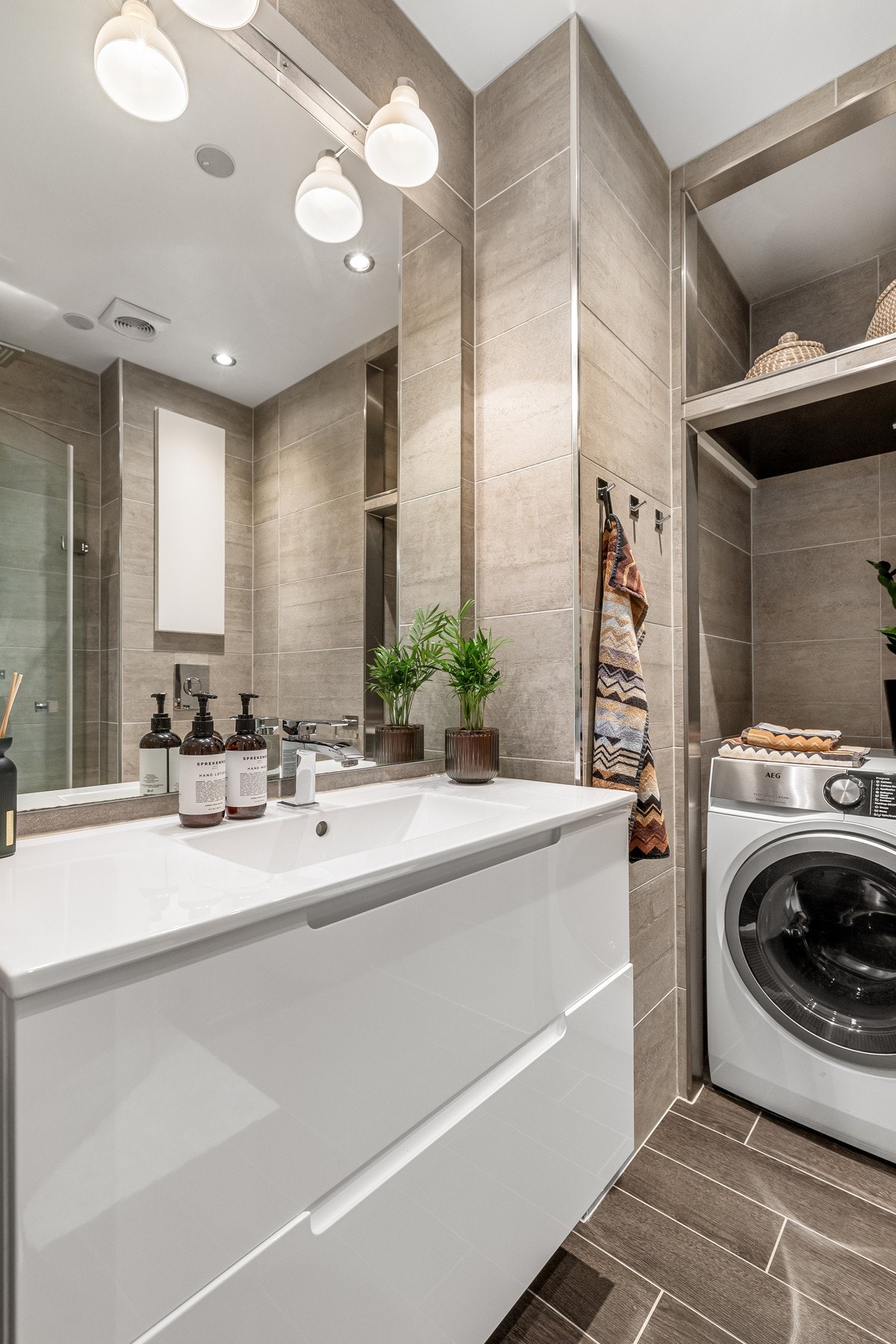 Spesielbestilt speil, belysning og baderomsinnredning på bad. Armatur fra Tapwell. Det er installert innebygde høyttalere i himling. Galleribilde