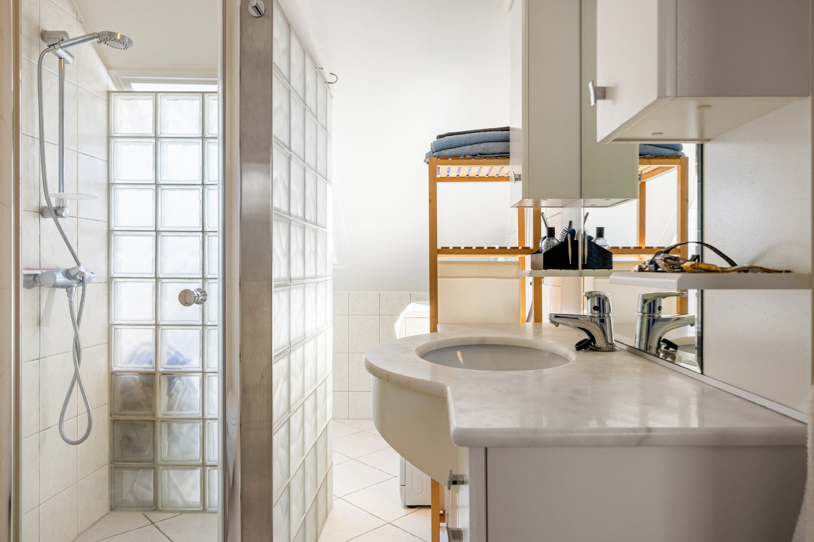 Baderommet består av toalett, dusj, og servant med oppbevaring. Galleribilde