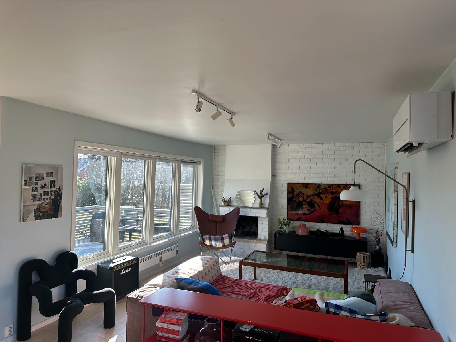 Lys stue med stort spisebord og vinduer ut mot hage og terrasse. Galleribilde