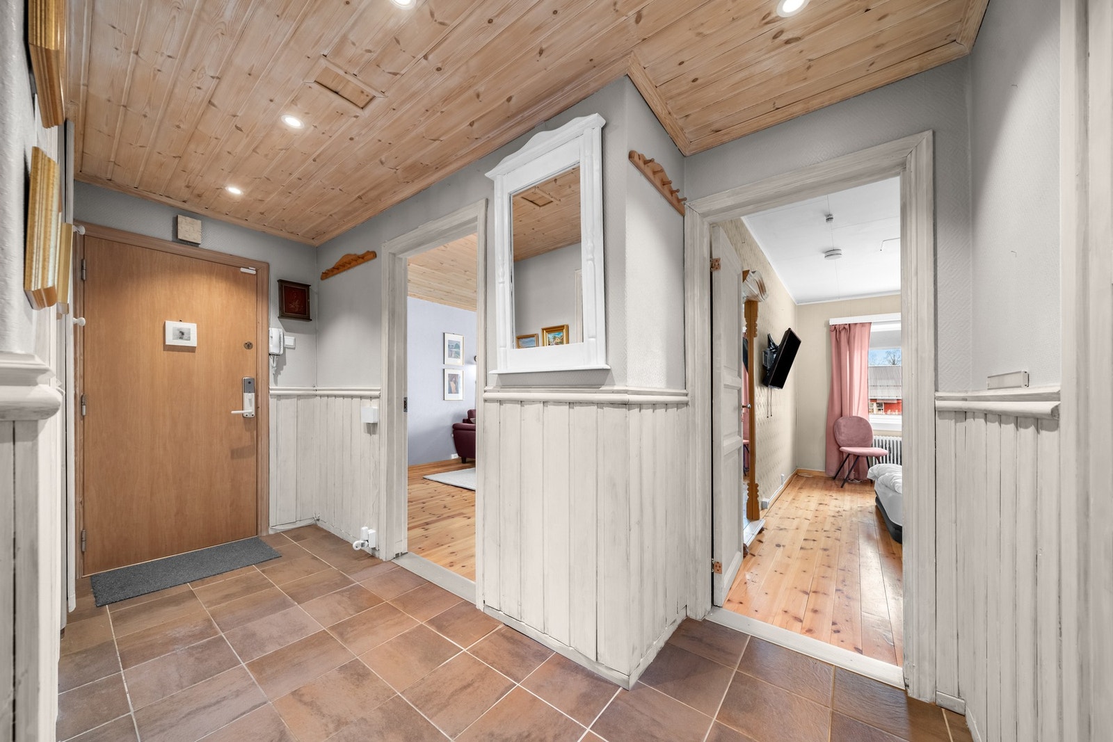 Entréen ønsker deg velkommen inn med flislagt gulv, brystpanel på veggene og panel i tak med innfelte spotter. Galleribilde