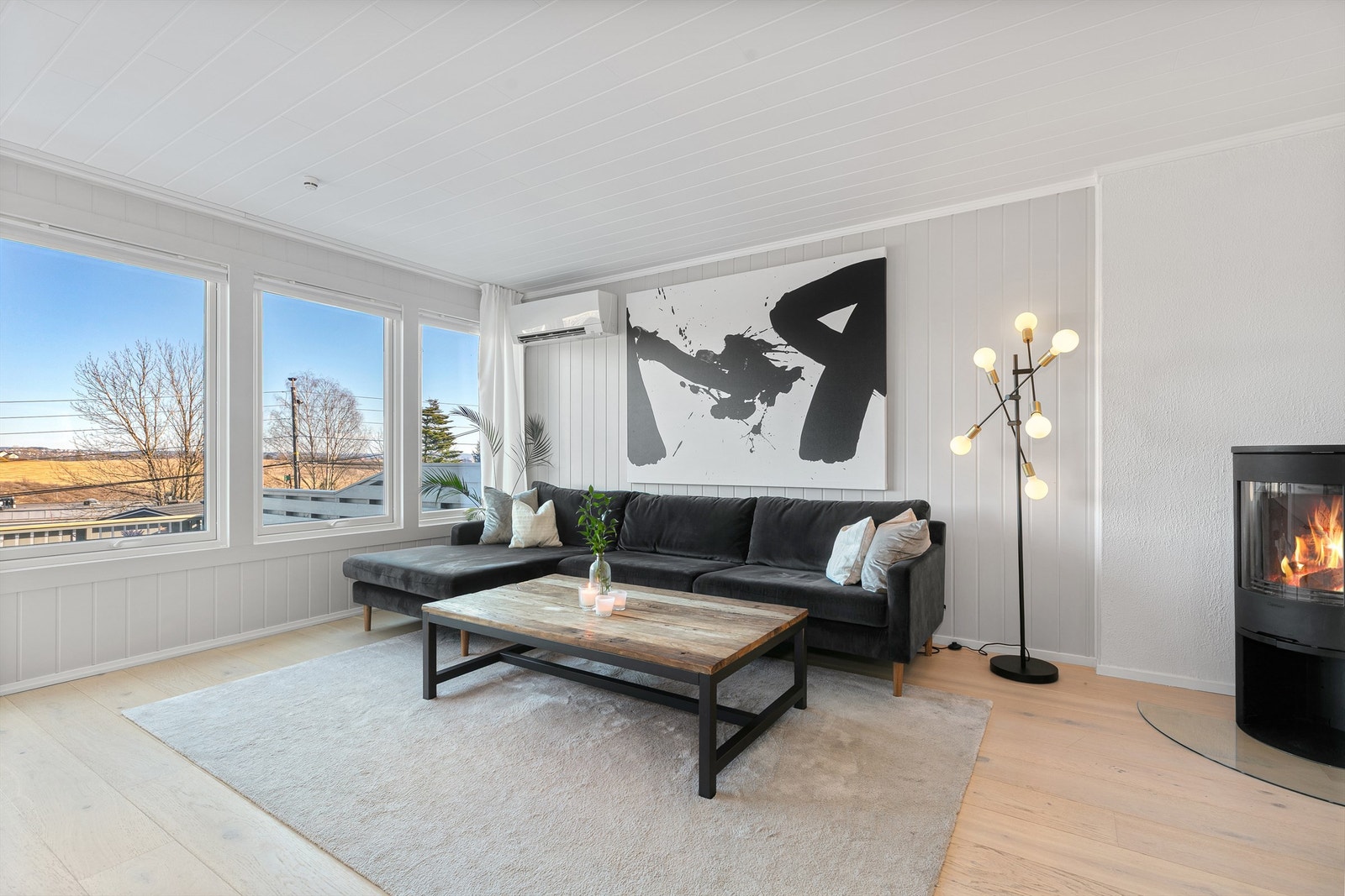 Stuen er åpen og innbydende med peisovn og varmepumpe. Galleribilde