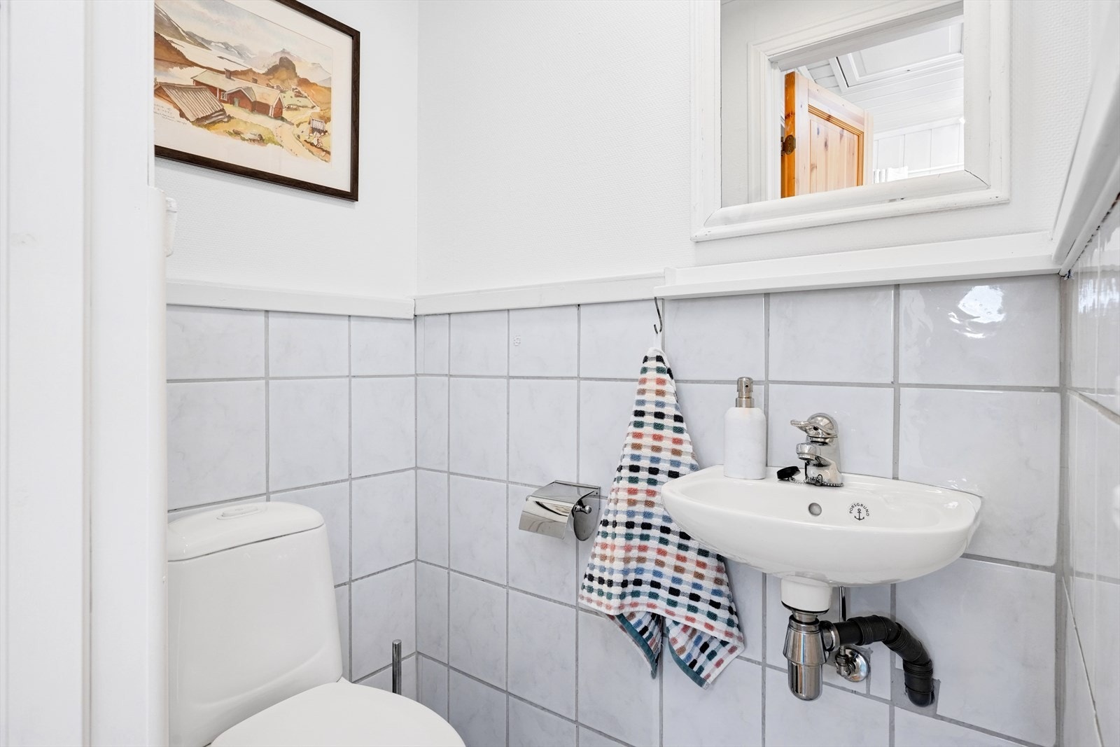 Ved inngangen er det et eget, praktisk toalettrom med flislagt gulv, og fliser/malte plater på veggene. Galleribilde