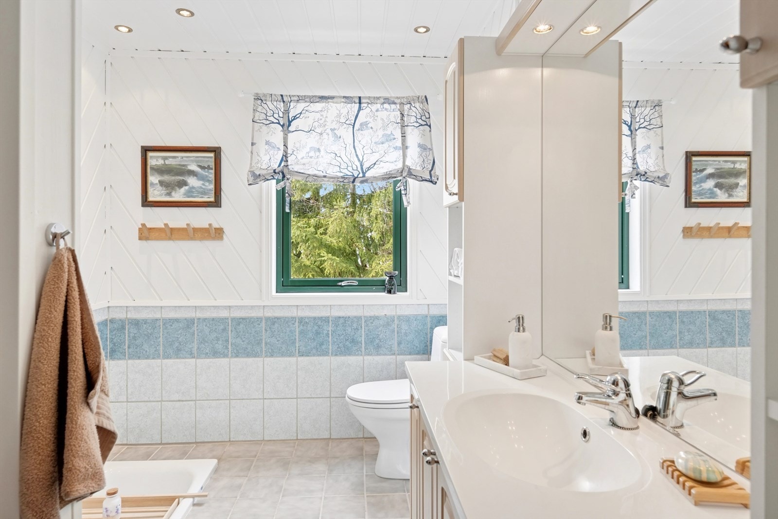 Badet pent bad med fliser og trepanel på veggene, og flislagt gulv med behagelige varmekabler. Galleribilde