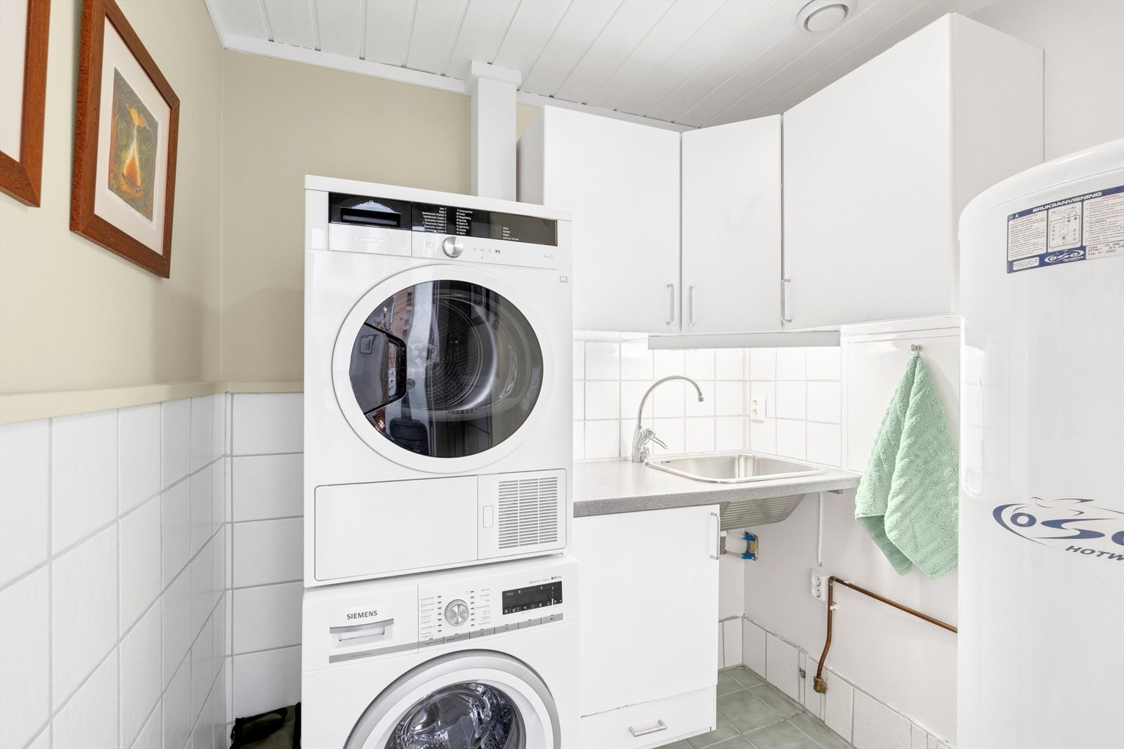 Eget vaskerom med innredning og opplegg for vaskemaskin her, samt at varmtvannstank og vannfordelingsskap er plassert her. Galleribilde