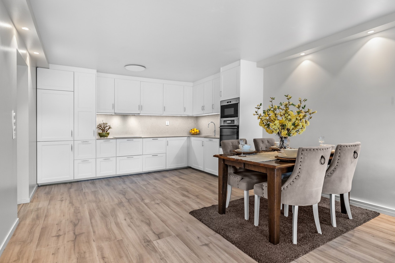 Kjøkkenet ble fornyet i 2023 og fremstår både elegant og funksjonelt. Her finner du profilerte, hvite fronter og en lekker steinbenkeplate i beige nyanse som står i kontrast til innredningen. Galleribilde