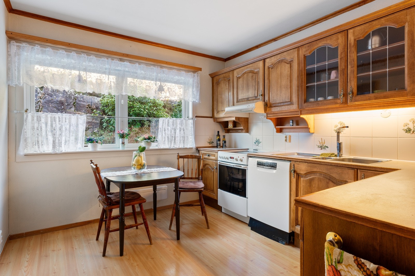 - Kjøkkenet har eldre innredning med profilerte fronter, laminat benkeplate og fliser mellom benkeplate og overskap - Galleribilde