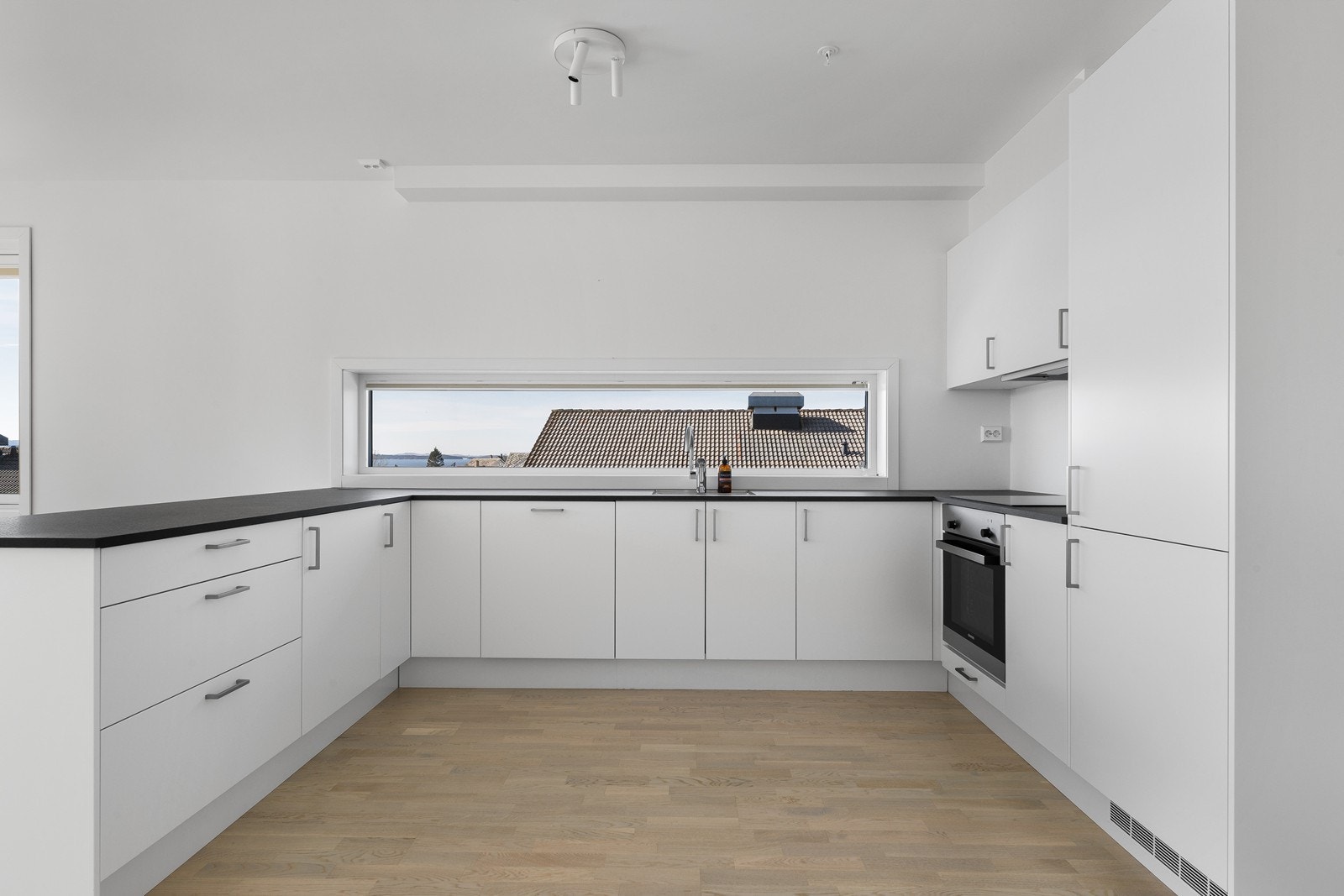 Kjøkkenet er innredet med koketopp, stekeovn, oppvaskmaskin og kjøleskap. Galleribilde