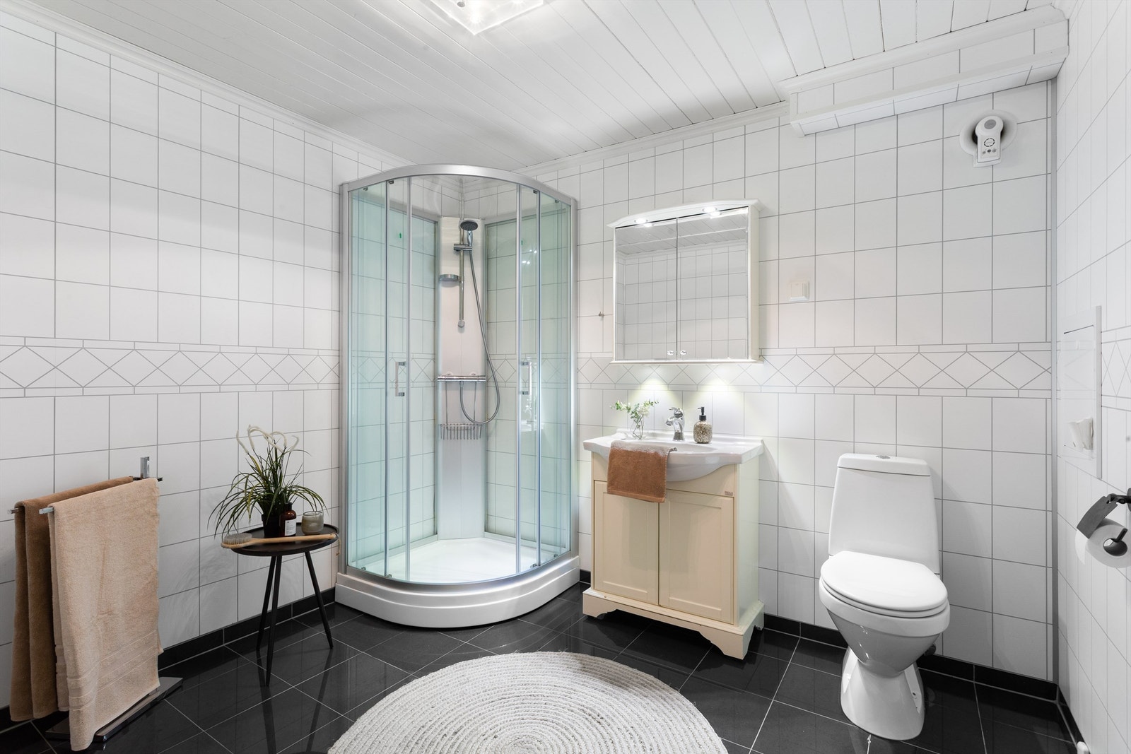 Bad med glislagt gulv med varme. Våtromsplater på vegger. Galleribilde