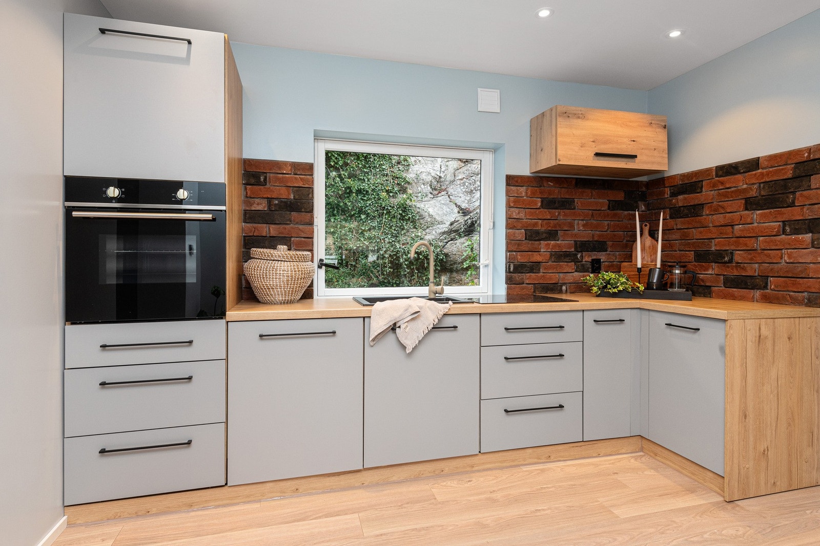 . Kjøkkensonen defineres av moderne kjøkkeninnredning med slette fronter og laminert benkeplate. Galleribilde