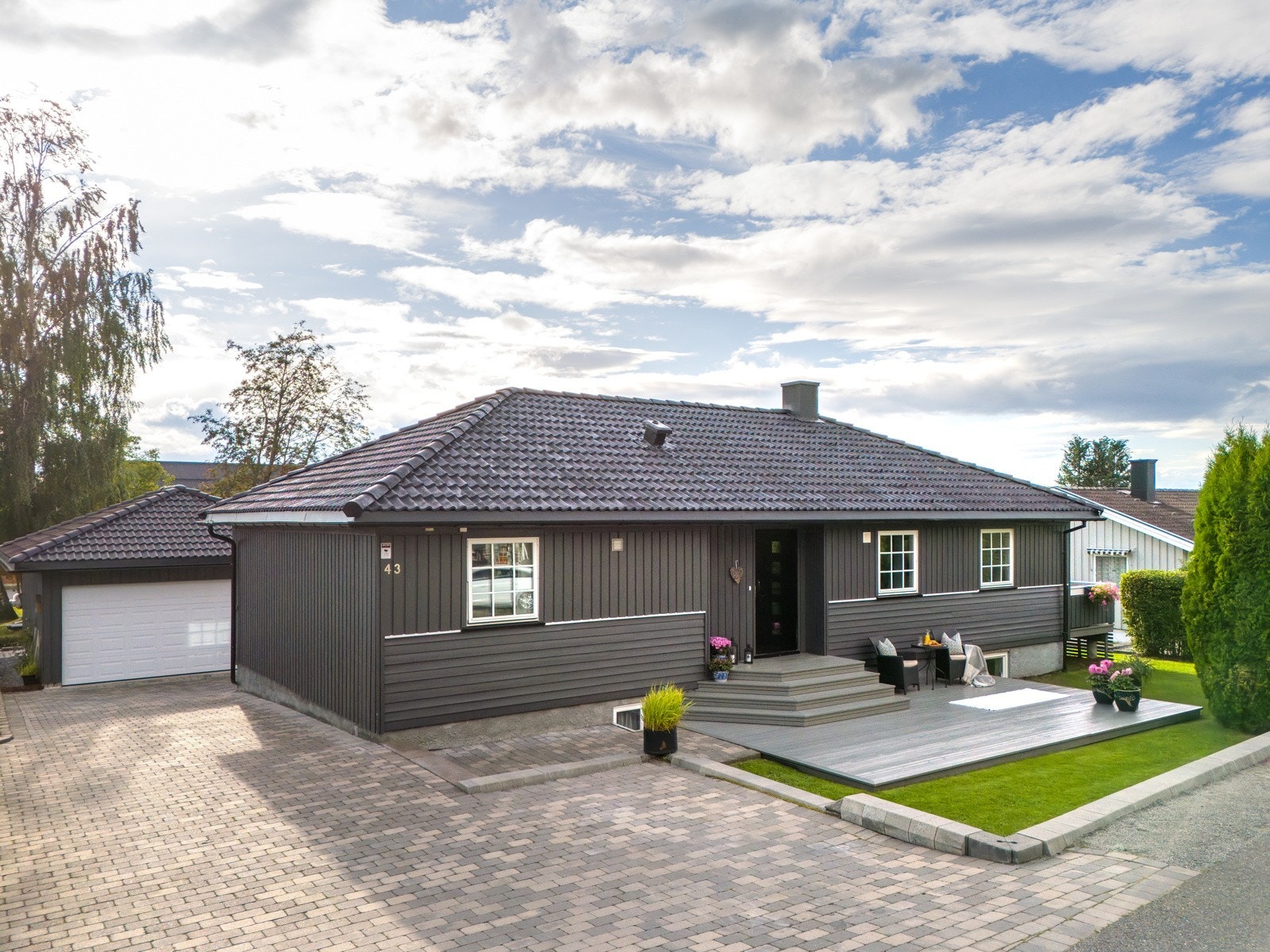 På siden av huset ligger dobbelgarasjen som ble oppført i 2018. Det er også parkeringsmuligheter ved inngangen. Galleribilde