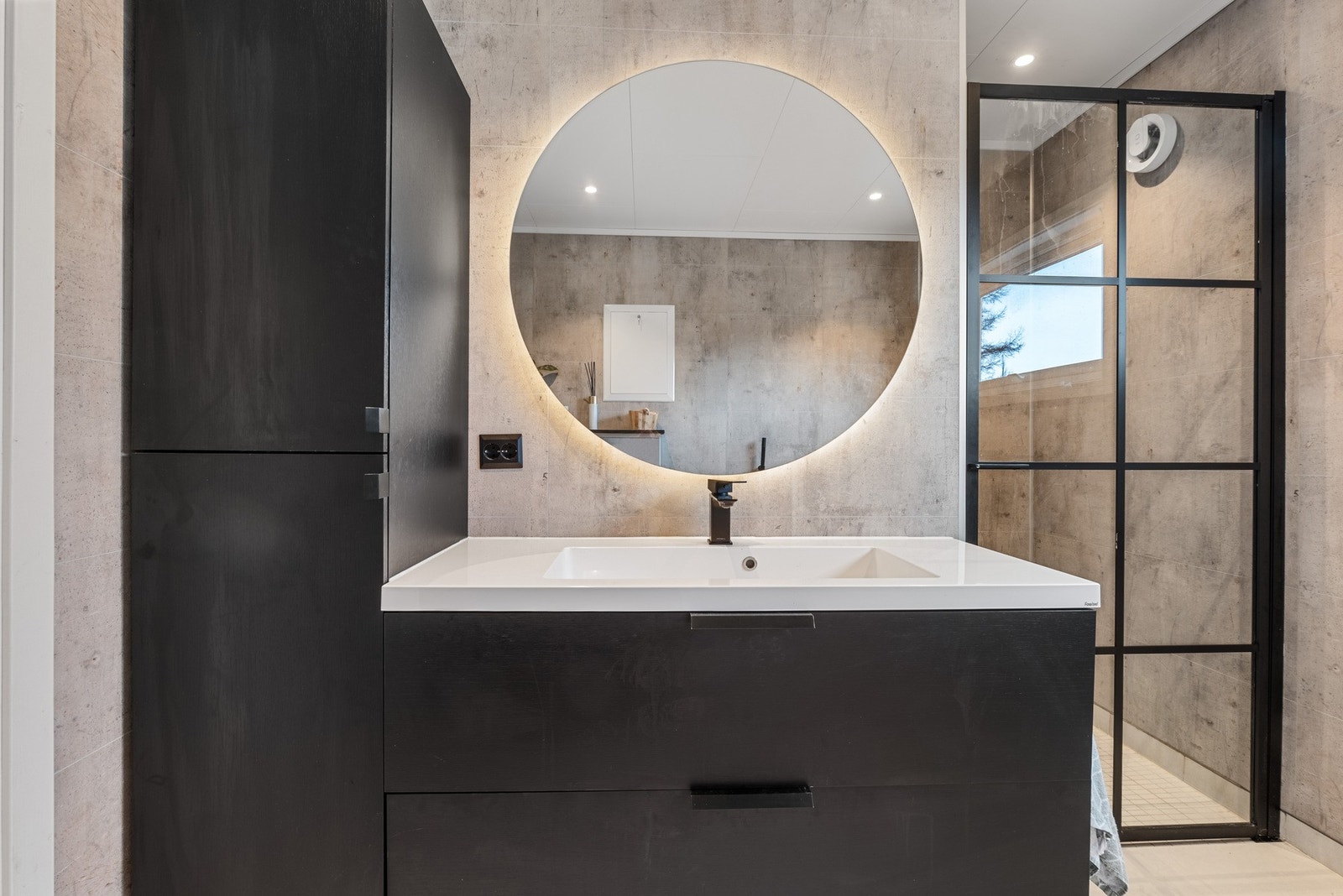 Ny baderomsinnredning med sorte detaljer, rundspeil med integrert LED_belysning og elegant dusjdør. Galleribilde