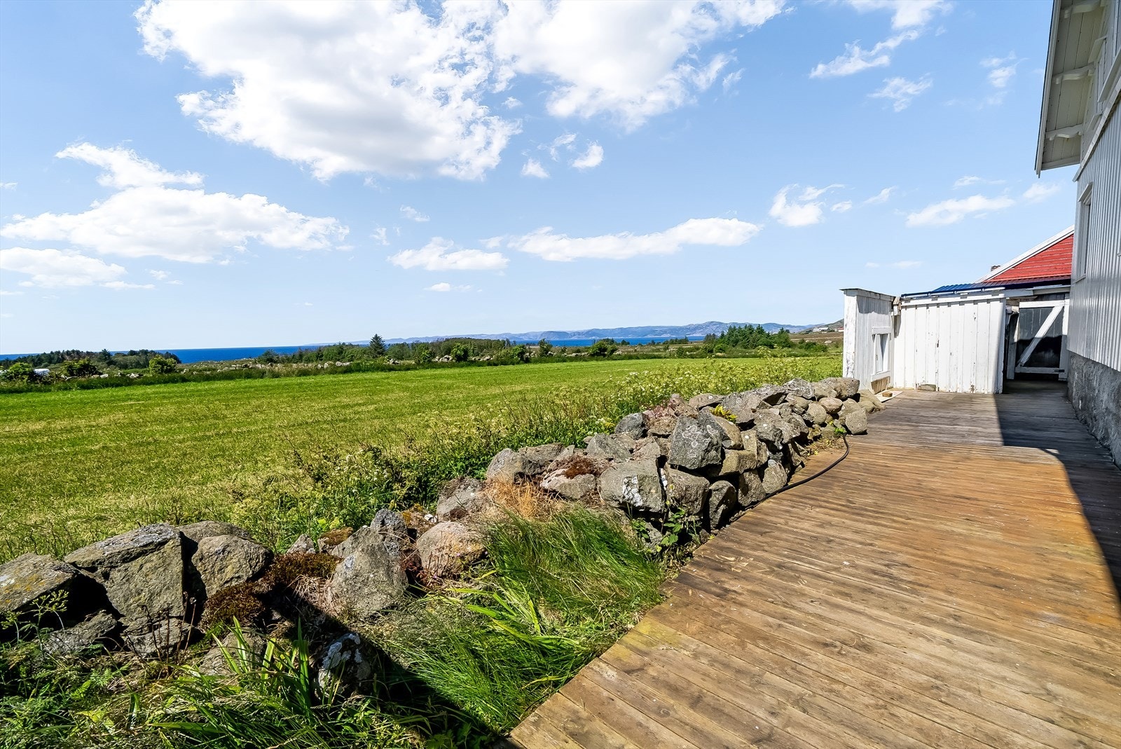 Terrasse rundt boligen med avgrensning til steingjerde. Galleribilde