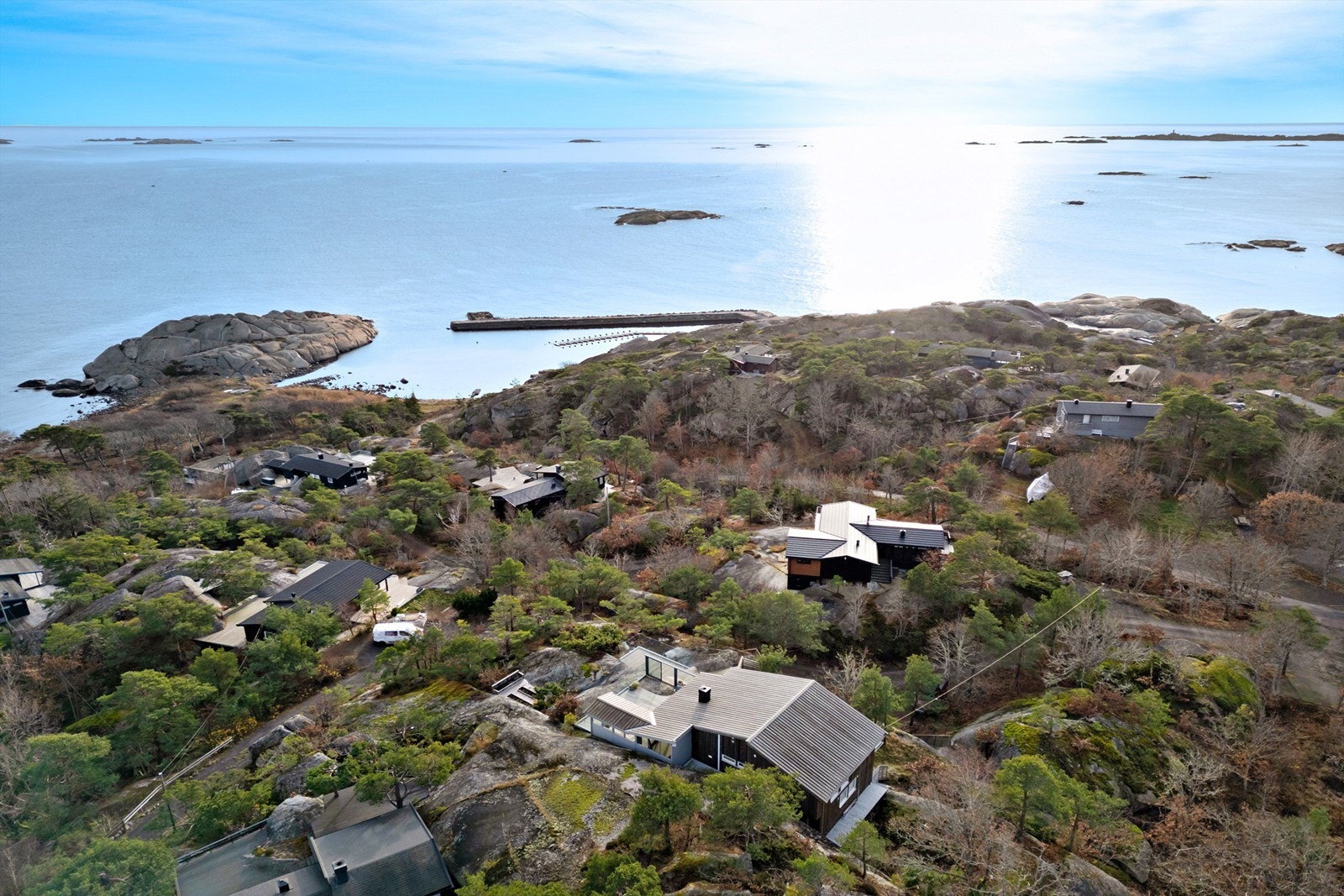 I midten av bildet skimter du veien ned til havna (250 meter). Helt til høyre en lekeplass med huske og basketbane. Galleribilde