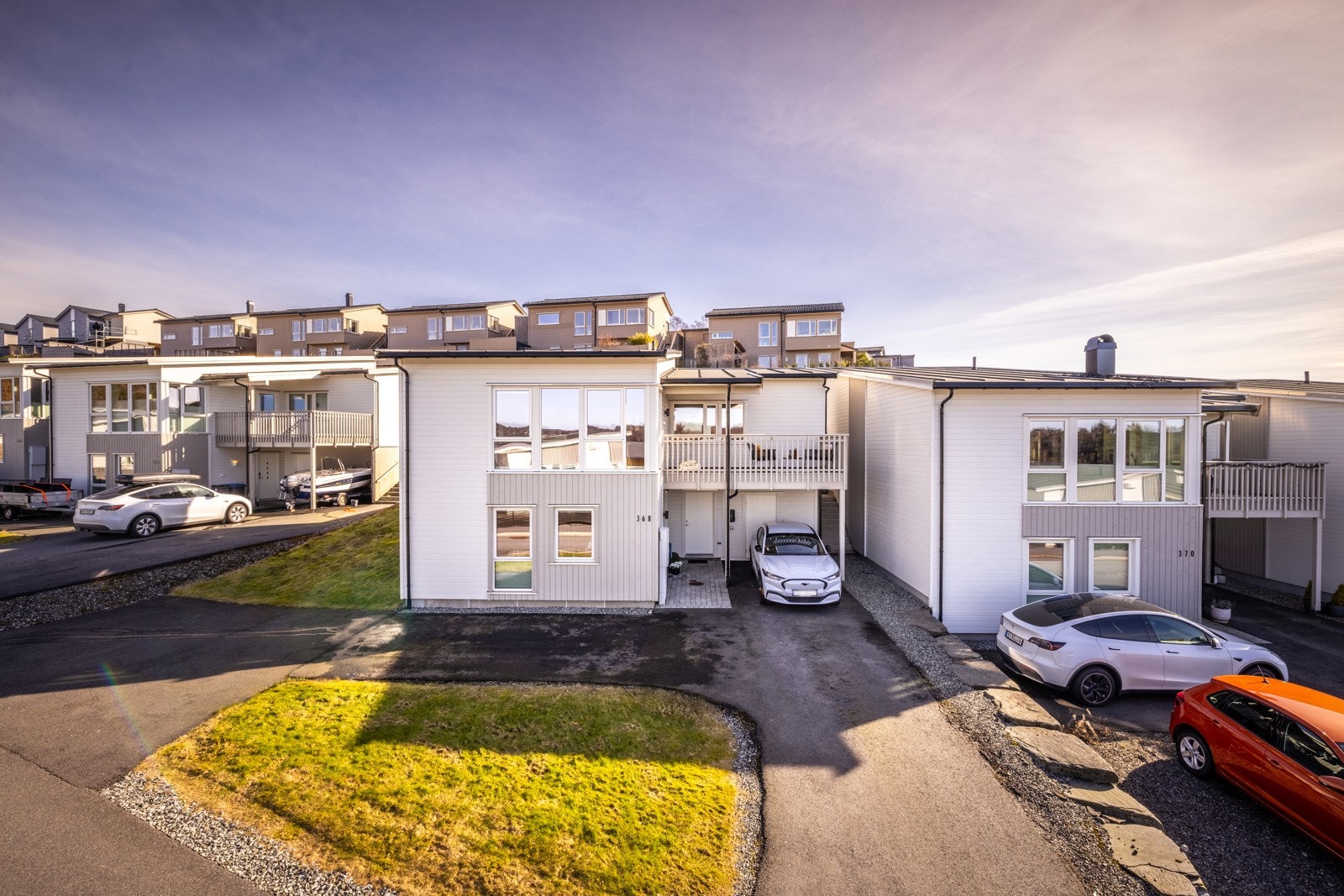 - Et lekkert hus. Legg merke til den asfalterte gjesteparkeringen i nordøst hjørne av tomten. Det er også to små plener på tomten. Plenflekk foran huset og langs øst siden av huset, denne plenen connecter med terrassen bak huset. - Galleribilde