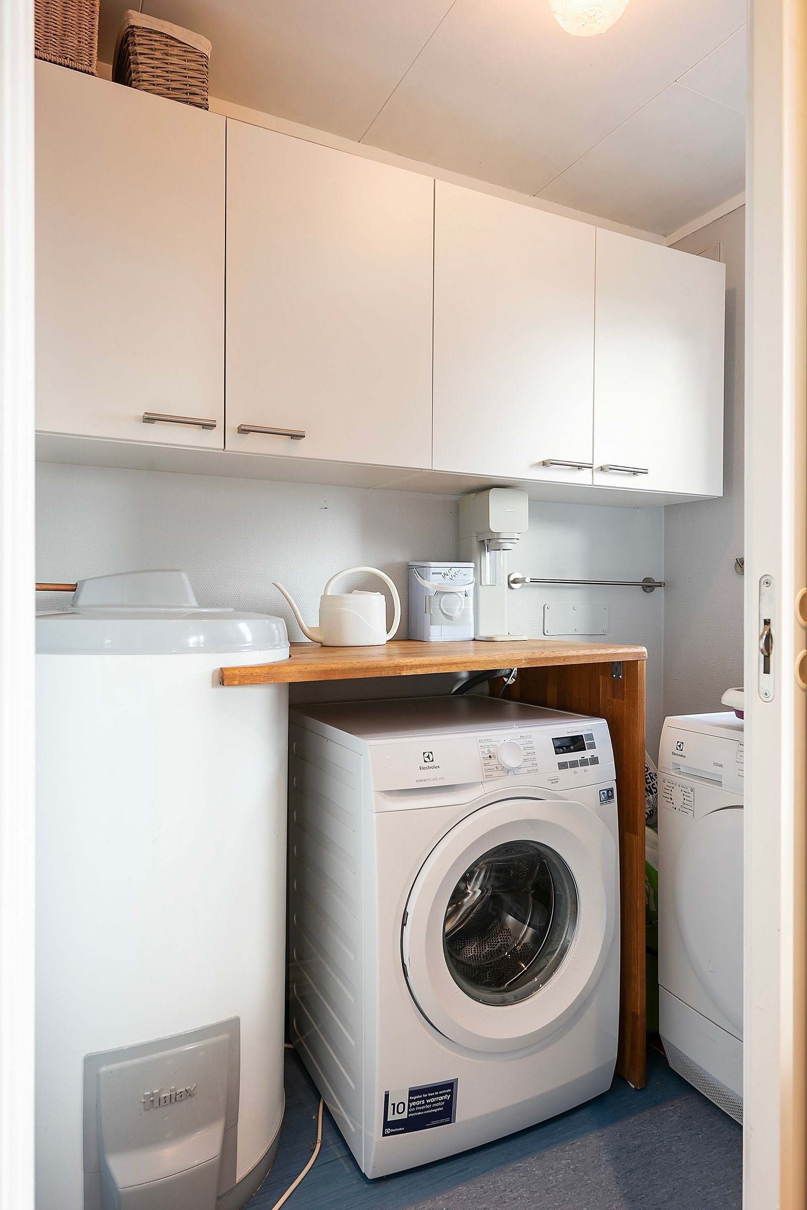 Innenfor kjøkkenet har du praktisk vaskerom med god skapplass Galleribilde