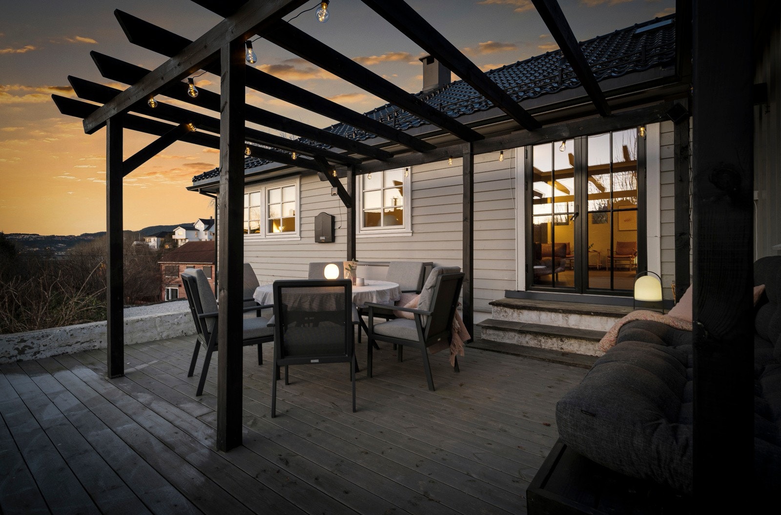 På husets vestside er det utgang fra stuen til uteplass med pergola Galleribilde