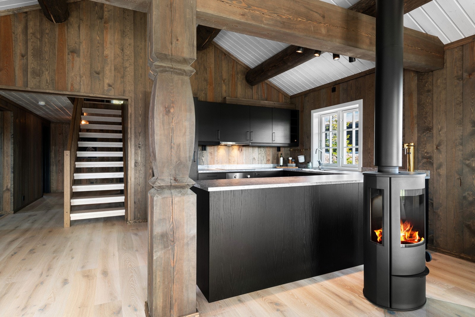 Et sosialt allrom der kjøkkenet har en kledelig innredning med integrerte hvitevarer. Galleribilde