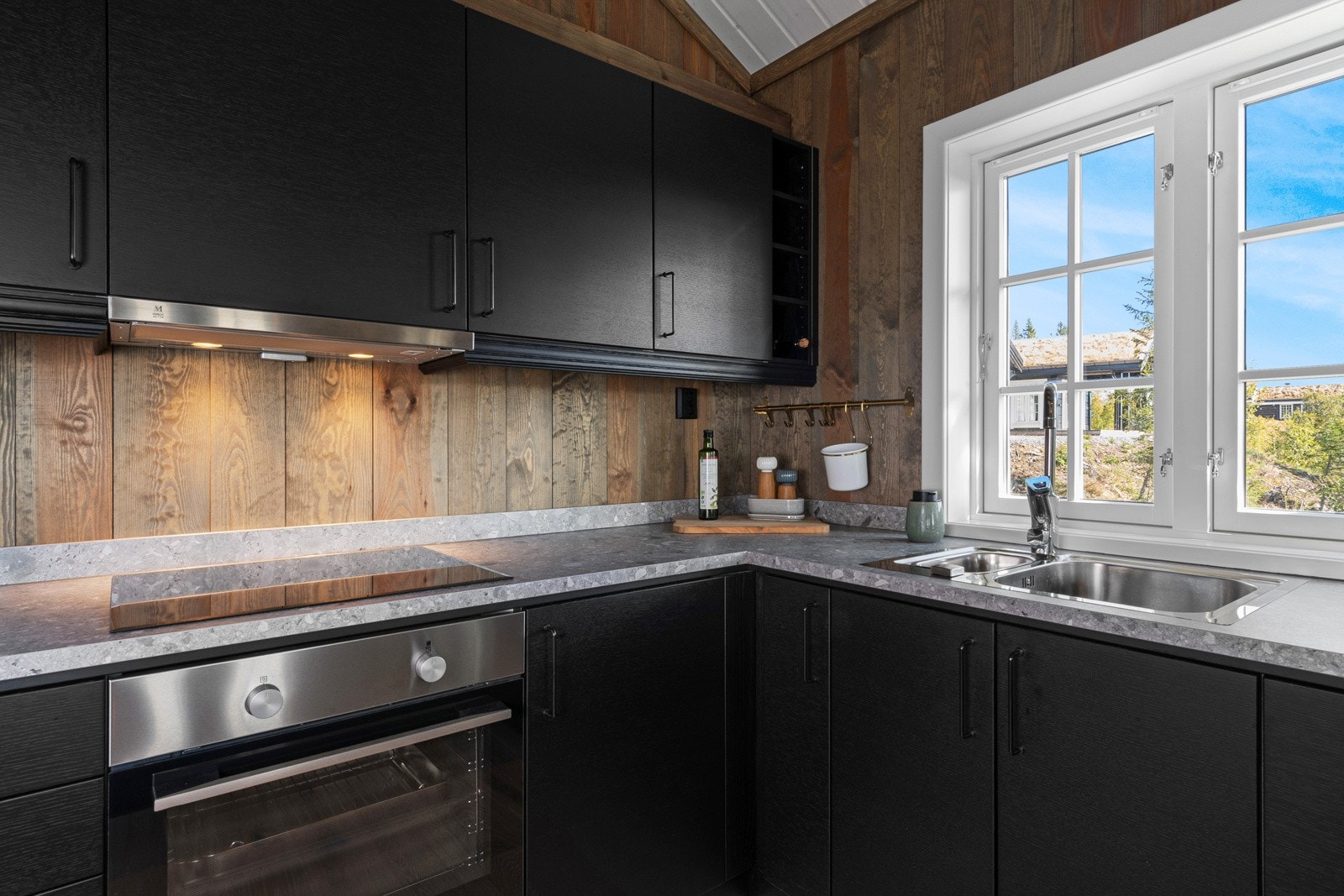 Kjøkkenet har en kledelig innredning fra Drømmekjøkkenet med integrerte hvitevarer og bardisk mot stuen. Galleribilde